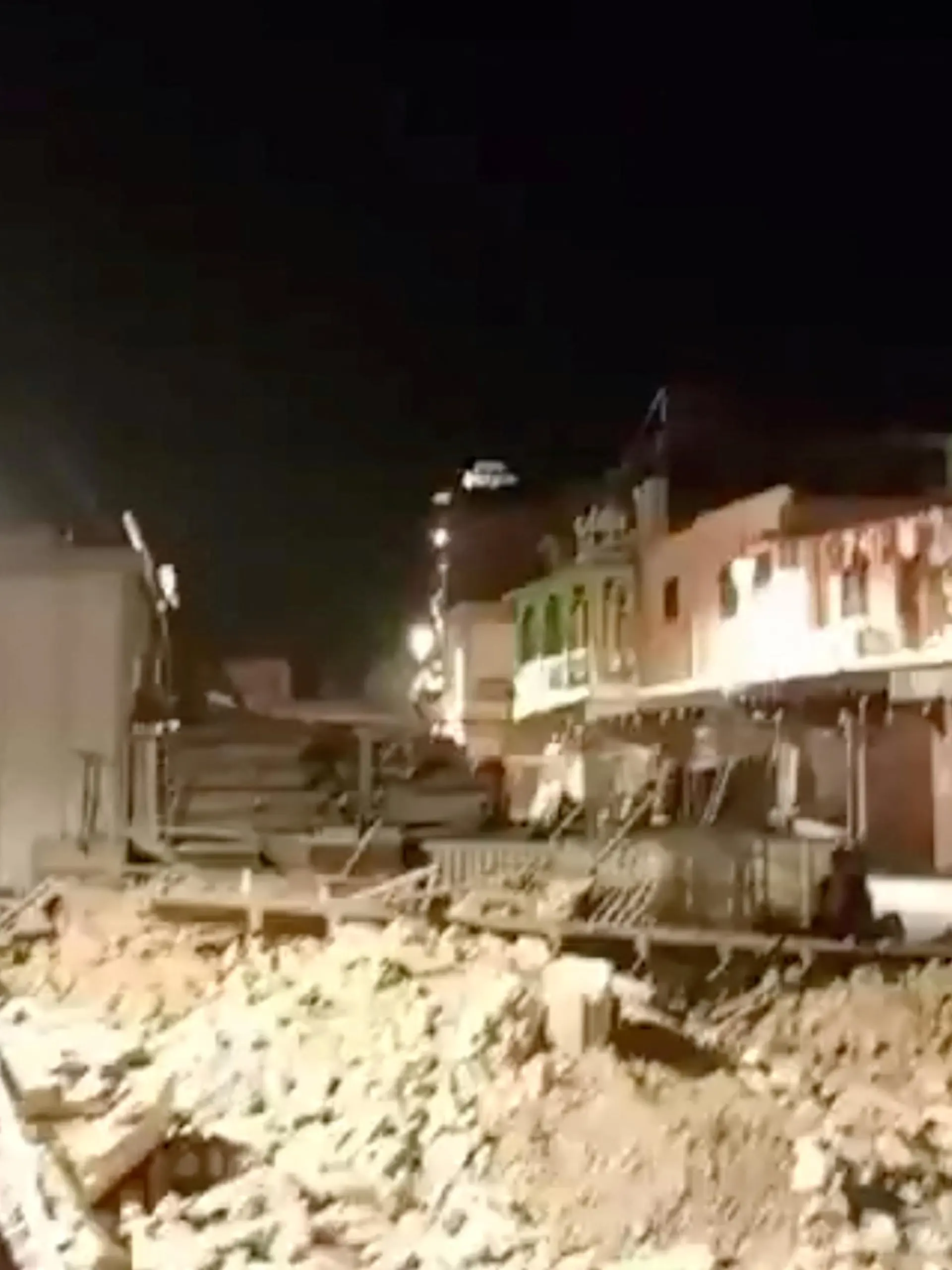 People look at debris in the aftermath of an earthquake in Marrakech, Morocco September 9, 2023 in this screen grab from a social media video in this picture. Al Maghribi Al Youm/via REUTERS  THIS IMAGE HAS BEEN SUPPLIED BY A THIRD PARTY. MANDATORY CREDIT. NO RESALES. NO ARCHIVES.