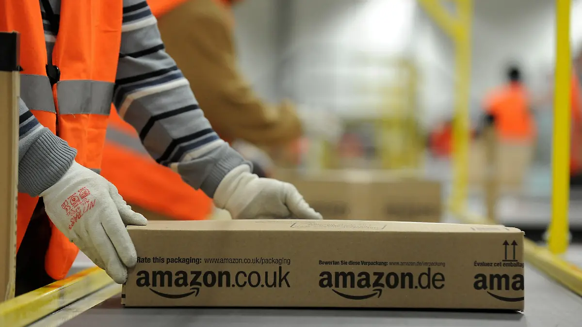 ARCHIV - Ein Mitarbeiter der Versandabteilung des Amazon Logistikzentrums in Pforzheim (Baden-Württemberg) legt am 11.12.2012 ein fertig verpacktes Paket auf ein Fließband. Der Kölner Enthüllungsjournalist Wallraff hat die Arbeitsbedingungen bei dem in die Kritik geratenen Internet-Versandhändler Amazon angeprangert. Foto: Jan-Philipp Strobel/dpa (zu dpa "Wallraff: «Grausamste» Arbeitsbedingungen bei Amazon" vom 18.02.2013) +++(c) dpa - Bildfunk+++