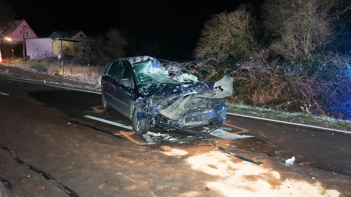 19.11.2022, Sachsen-Anhalt, Nehlitz: Ein zerstörtes Fahrzeug steht auf der Straße Bei einem Unfall mit einem Sattelzug auf einer Landstraße im Saalekreis sind am späten Freitagabend zwei Menschen gestorben. Nahe der Ortschaft Nehlitz war ihr Auto vom Auflieger eines ins Schleudern geratenen Sattelzugs gerammt und unter diesem «begraben worden». Foto: Tom Musche/dpa +++ dpa-Bildfunk +++