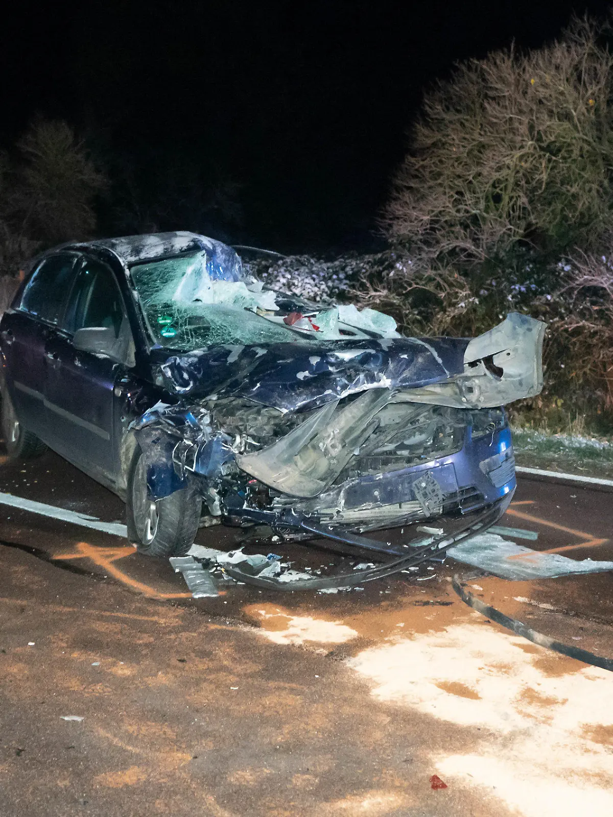 19.11.2022, Sachsen-Anhalt, Nehlitz: Ein zerstörtes Fahrzeug steht auf der Straße Bei einem Unfall mit einem Sattelzug auf einer Landstraße im Saalekreis sind am späten Freitagabend zwei Menschen gestorben. Nahe der Ortschaft Nehlitz war ihr Auto vom Auflieger eines ins Schleudern geratenen Sattelzugs gerammt und unter diesem «begraben worden». Foto: Tom Musche/dpa +++ dpa-Bildfunk +++