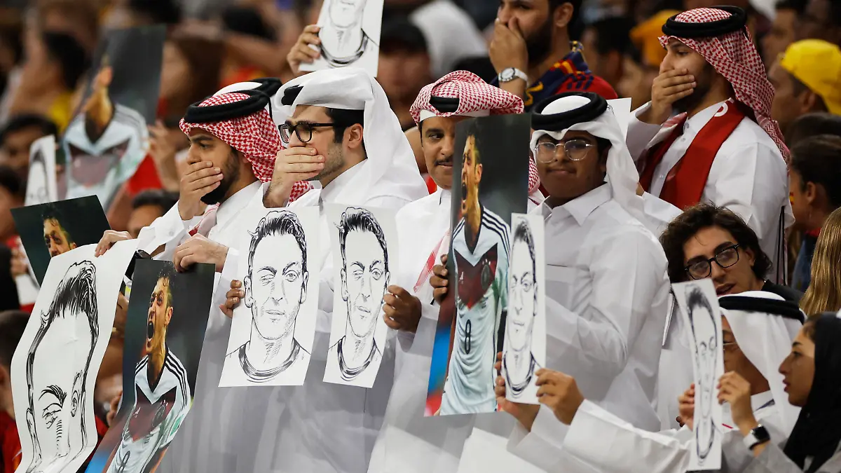 Soccer Football - FIFA World Cup Qatar 2022 - Group E - Spain v Germany - Al Bayt Stadium, Al Khor, Qatar - November 27, 2022 Fans hold up signs displaying former Germany player Mesut Ozil in the stands REUTERS/John Sibley