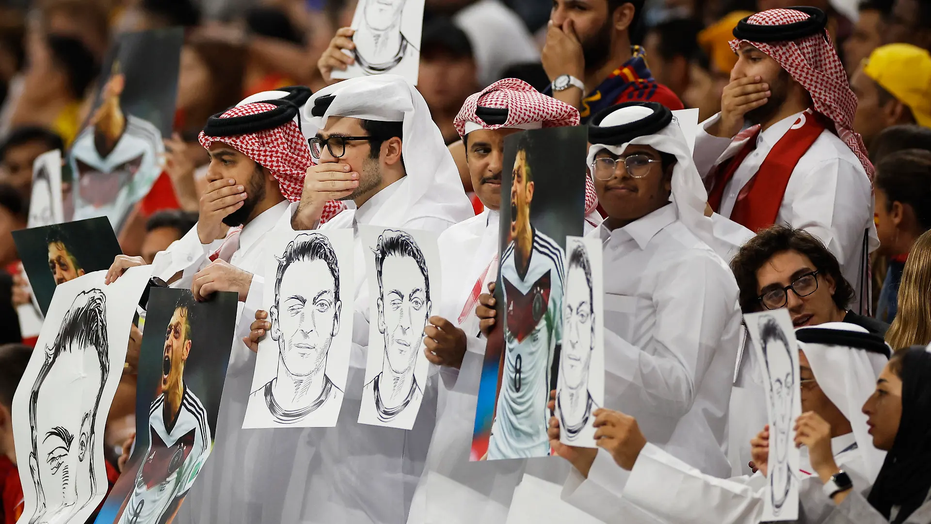 Soccer Football - FIFA World Cup Qatar 2022 - Group E - Spain v Germany - Al Bayt Stadium, Al Khor, Qatar - November 27, 2022 Fans hold up signs displaying former Germany player Mesut Ozil in the stands REUTERS/John Sibley