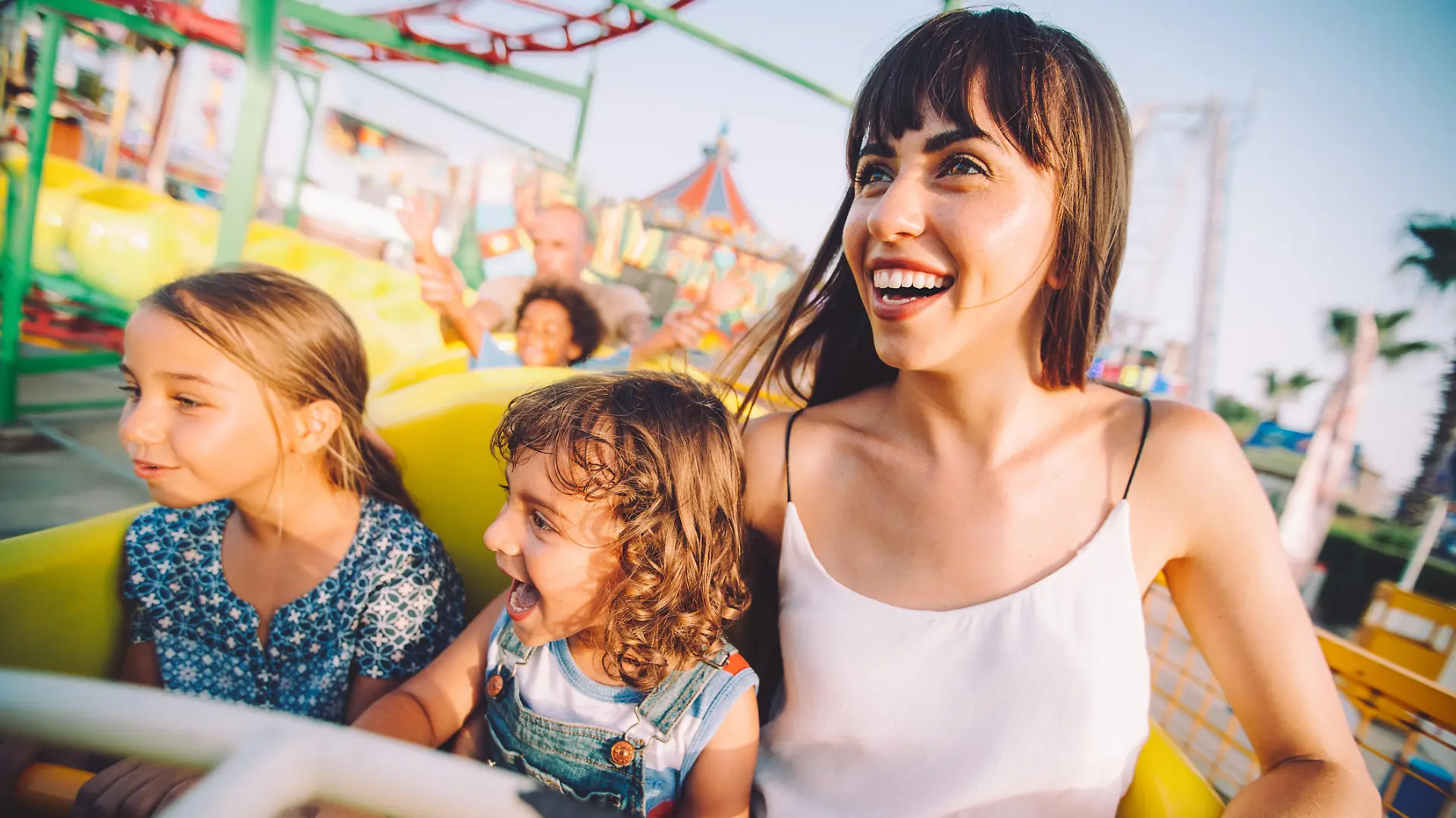 Mutter, die mit ihren Kindern Achterbahn fährt.