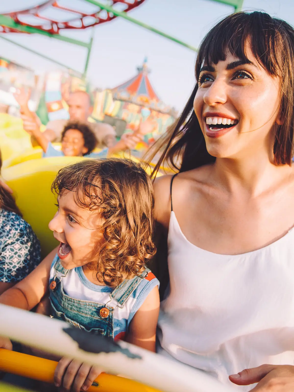 Mutter, die mit ihren Kindern Achterbahn fährt.