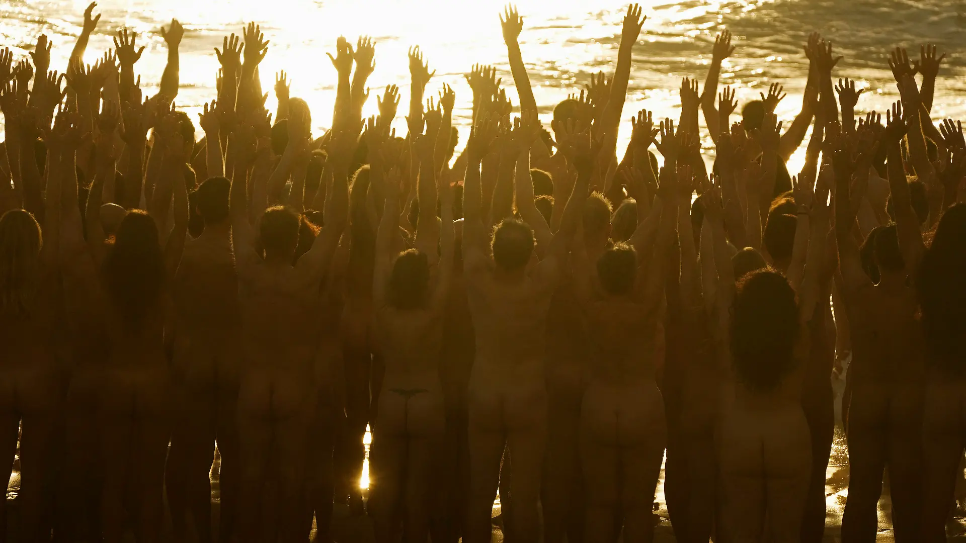 25.11.2022, Australien, Sydney: Einige der Hunderten von nackten Menschen posieren für den Künstler und Fotografen Spencer Tunick am Bondi Beach in Sydney. Mit dieser Kunstaktion soll das Bewusstsein für die Bedeutung der Früherkennung von Hautkrebs geschärft werden. Foto: Rick Rycroft/AP/dpa - ACHTUNG: Verwendung nur im vollen Format - EDS-HINWEIS: Nacktheit - +++ dpa-Bildfunk +++