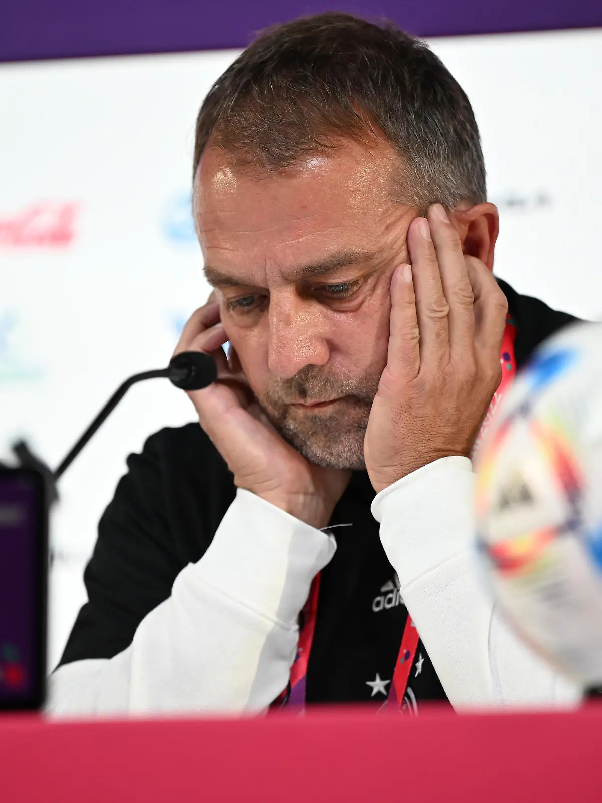 Fußball: WM, Nationalmannschaft, Gruppe E, Bundestrainer Hansi Flick sitzt wartet während einer Pressekonferenz hinter dem Mikrofon.