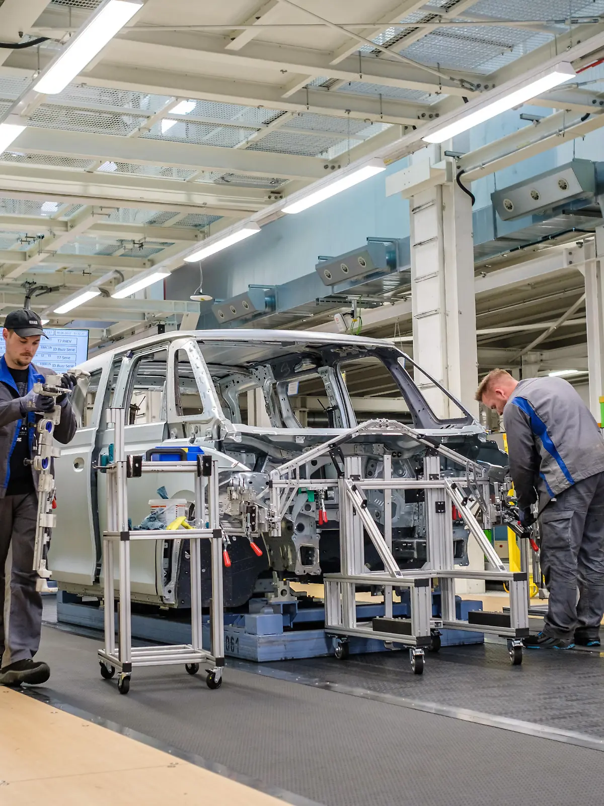 Mitarbeiter arbeiten während einer Werksführung zur Produktion des ID. Buzz im Volkswagen Nutzfahrzeuge Werk in Hannover am Band der ID. Buzz Produktion. Der vollelektrische Bulli ID. Buzz wird in Hannover gefertigt.