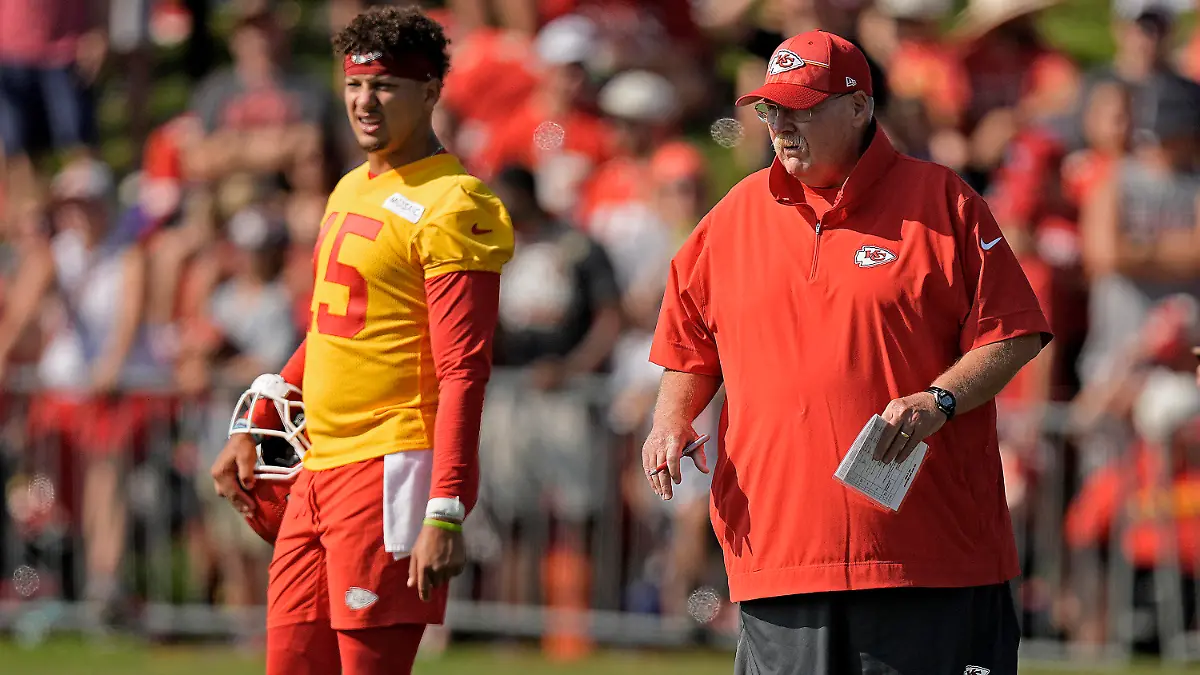 Kansas City Chiefs quarterback Patrick Mahomes (15) and head coach Andy Reid watch a drill during NFL football training camp Sunday, July 23, 2023, in St. Joseph, Mo. (AP Photo/Charlie Riedel)