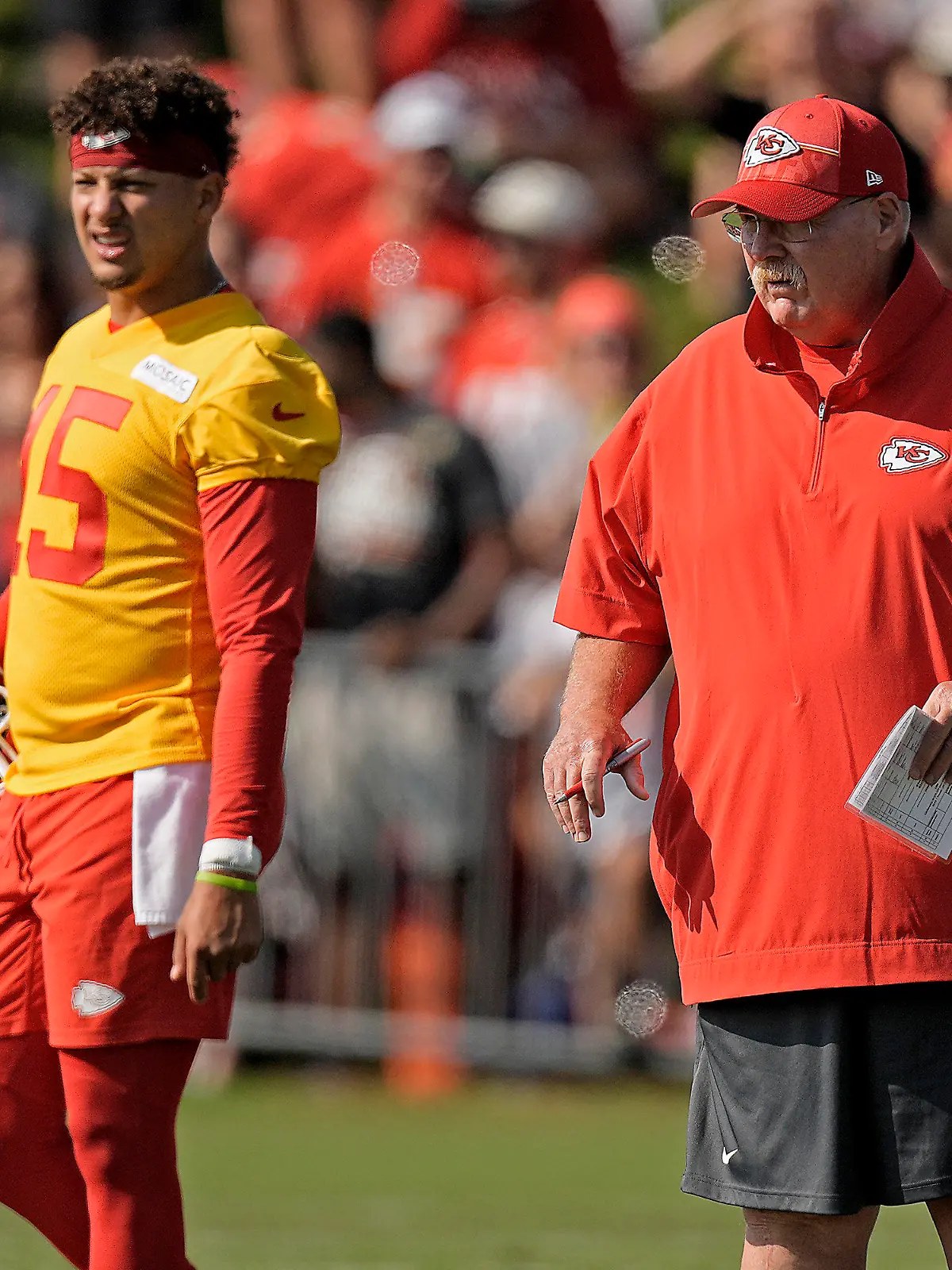 Kansas City Chiefs quarterback Patrick Mahomes (15) and head coach Andy Reid watch a drill during NFL football training camp Sunday, July 23, 2023, in St. Joseph, Mo. (AP Photo/Charlie Riedel)