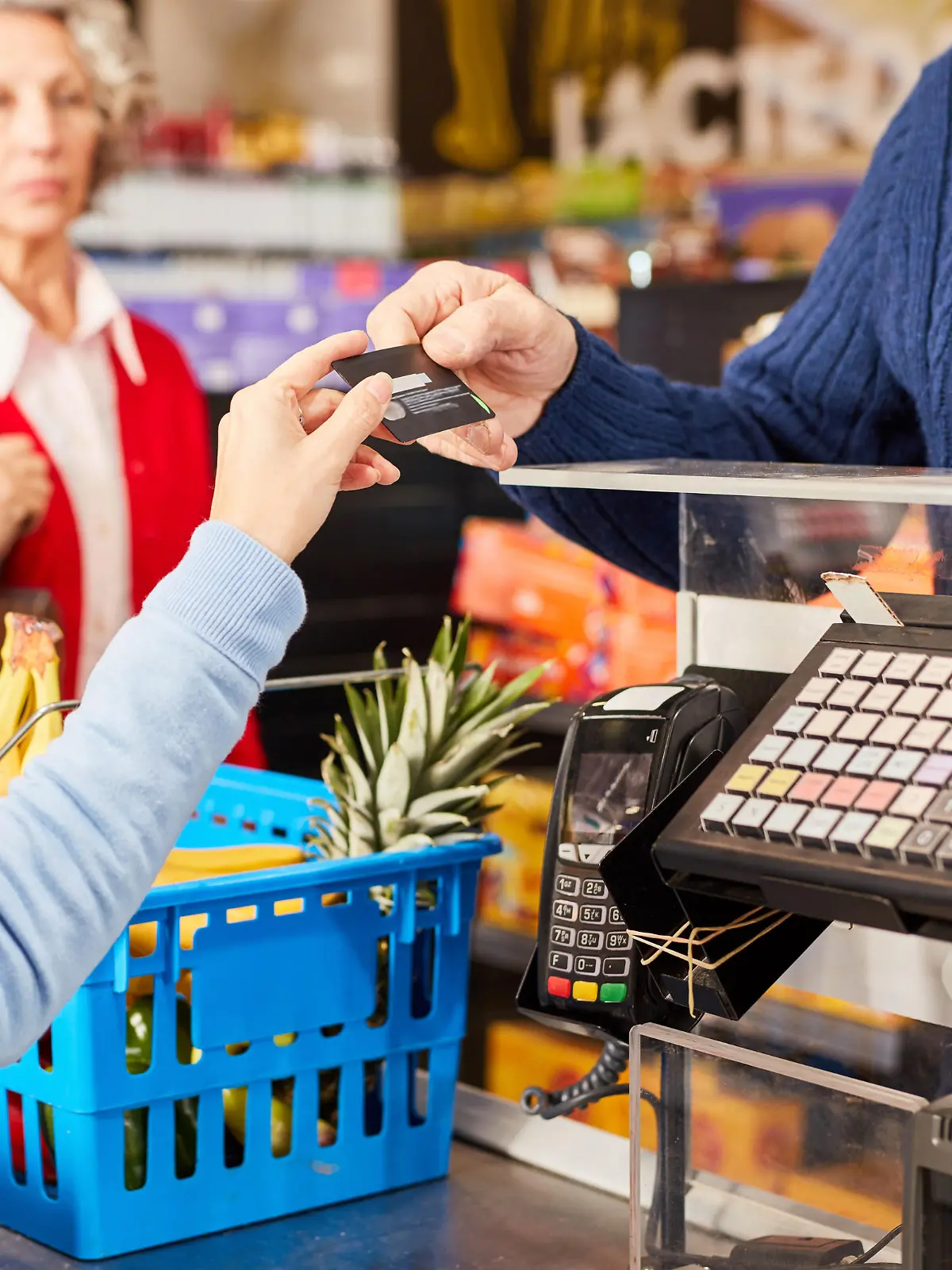 Kunde bezahlt mit Kreditkarte oder Kundenkarte an der Kasse im Supermarkt
