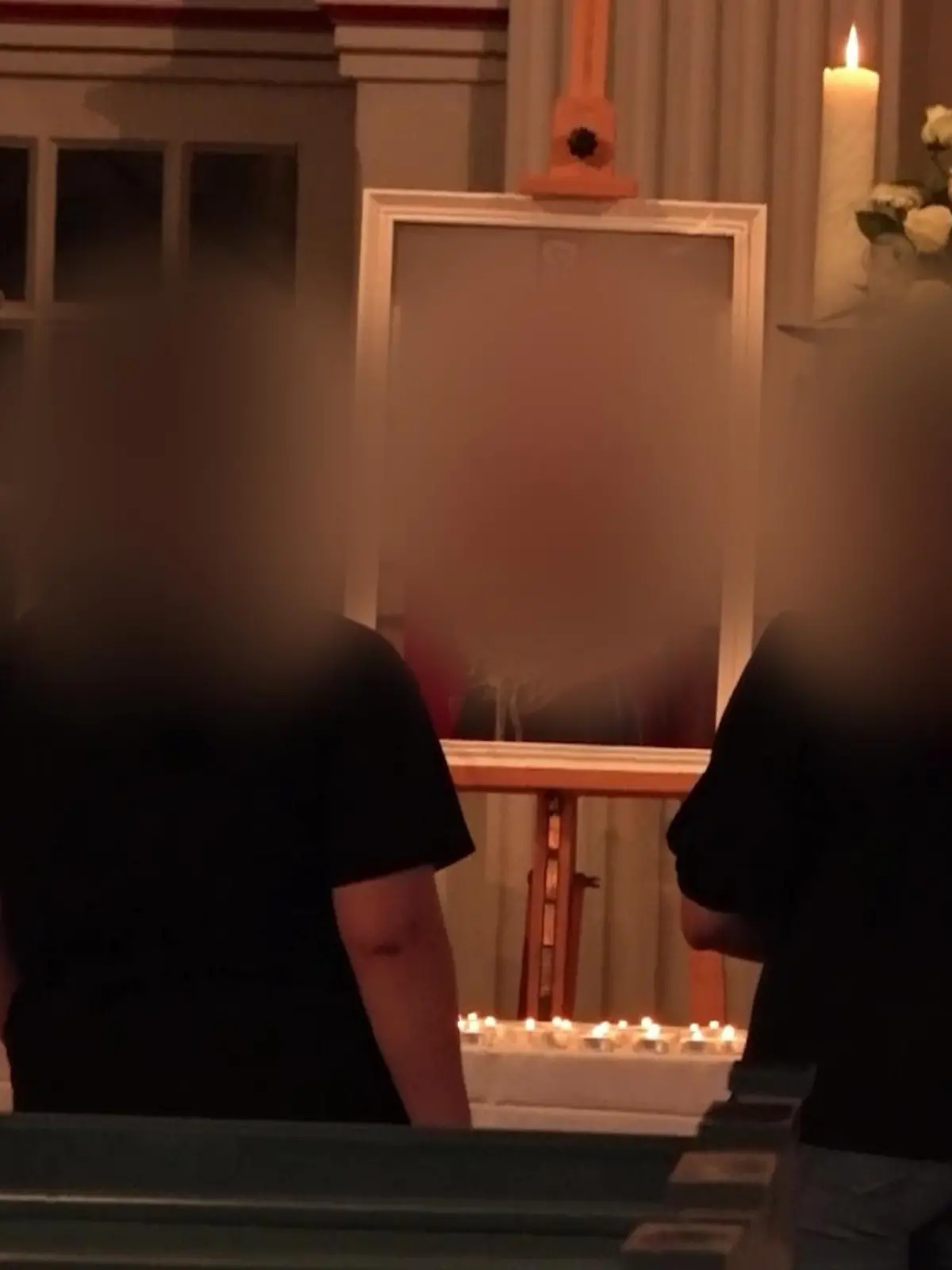 Ein Kirchenaltar geschmückt mit Blumen. Ein Foto von einer Frau steht davor