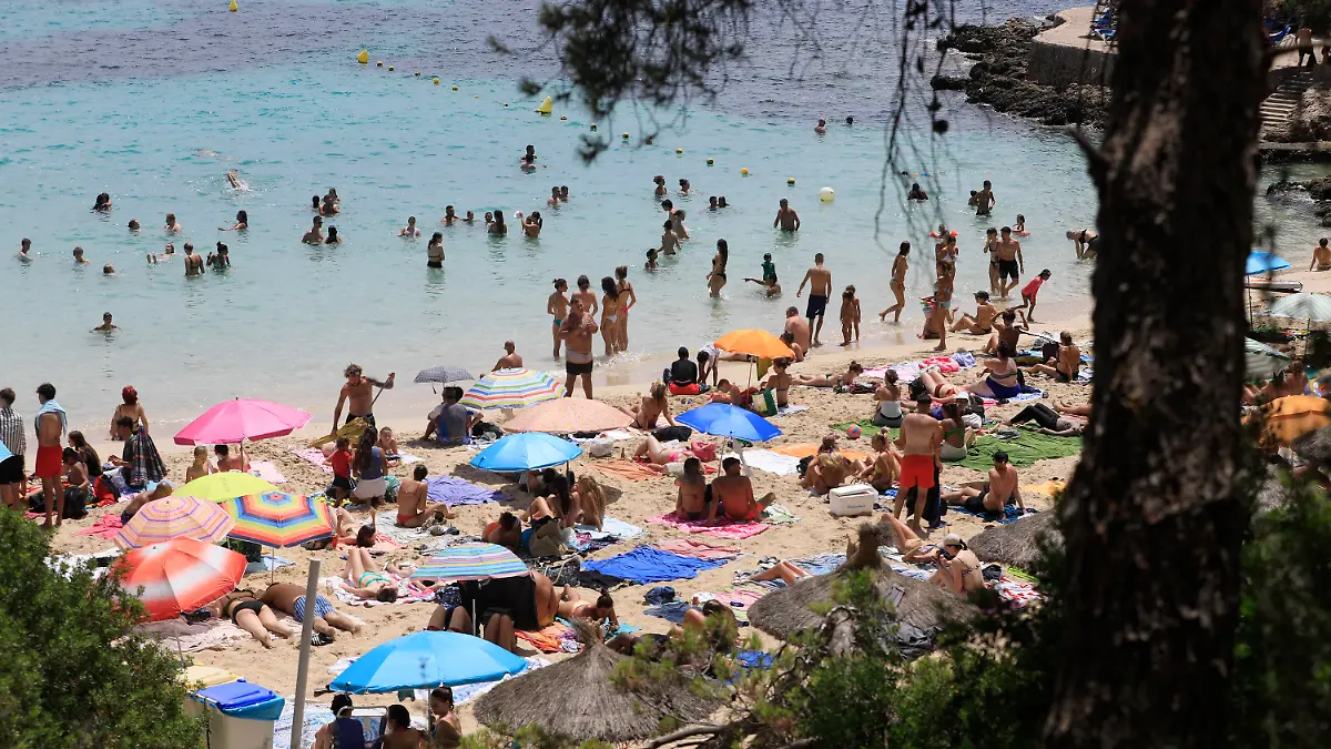 22.07.2023, Spanien, Calvia: Menschen schwimmen und sonnen sich am Strand von Illetes auf Mallorca. Das Mittelmeer erwärmt sich einer Studie zufolge immer schneller und wird dabei auch immer salziger. Das Wasser erwärme sich infolge des Klimawandels mit einer Geschwindigkeit von etwa zwei Grad je 100 Jahre im westlichen Mittelmeer und an einigen Stellen sogar um drei Grad pro Jahrhundert, schrieben Wissenschaftler des spanischen Meeresforschungsinstituts ICM-CSIC in der Zeitschrift «Journal of Marine Science and Engineering». Foto: Clara Margais/dpa +++ dpa-Bildfunk +++