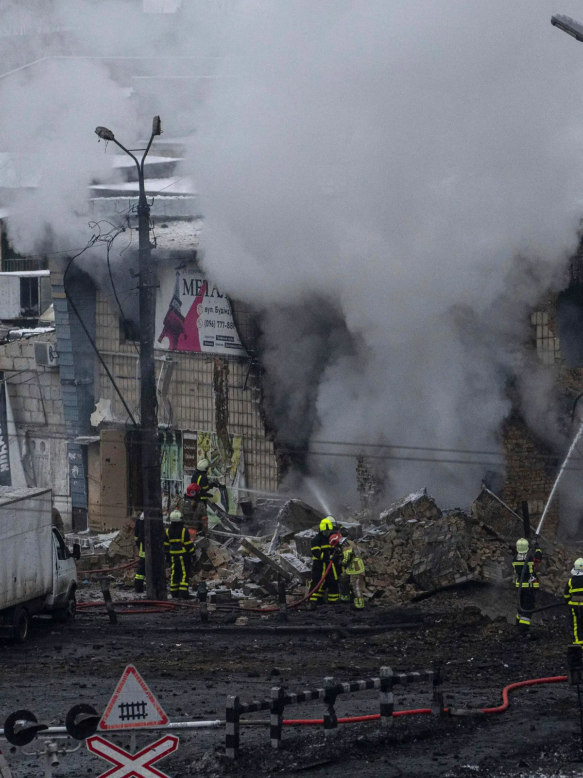 23.11.2022, Ukraine, Kiew: Feuerwehrleute des staatlichen ukrainischen Katastrophenschutzes löschen nach einem Raketenangriff ein Feuer. Bei neuen russischen Raketenangriffen auf Kiew und weitere Gebiete sind nach Angaben der Ukraine mehrere Menschen getötet worden, darunter ein Säugling in einem Krankenhaus. Foto: Evgeniy Maloletka/AP/dpa +++ dpa-Bildfunk +++