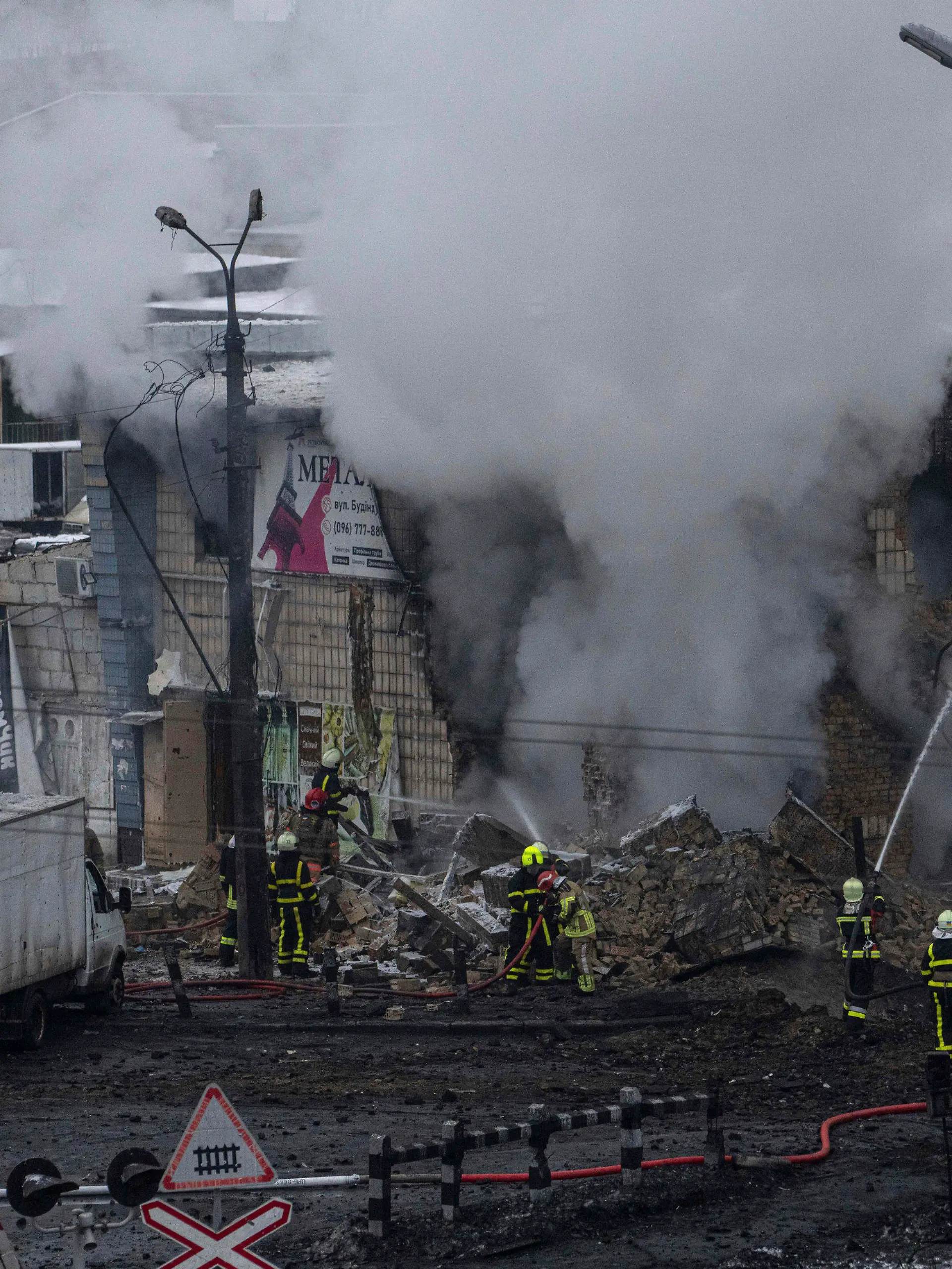23.11.2022, Ukraine, Kiew: Feuerwehrleute des staatlichen ukrainischen Katastrophenschutzes löschen nach einem Raketenangriff ein Feuer. Bei neuen russischen Raketenangriffen auf Kiew und weitere Gebiete sind nach Angaben der Ukraine mehrere Menschen getötet worden, darunter ein Säugling in einem Krankenhaus. Foto: Evgeniy Maloletka/AP/dpa +++ dpa-Bildfunk +++