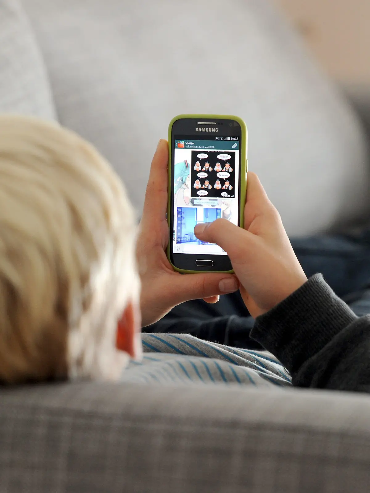 ARCHIV - 09.12.2014, Bayern, München: Ein Jugendlicher liegt auf einem Sofa und schaut auf sein Smartphone. Dauernd am Handy und mit Kettenbriefen, Mobbing oder Pornografie konfrontiert - die Mehrheit der Eltern berichtet von schlechten Erfahrungen ihrer Kids im Netz und fordert mehr gesetzlichen Schutz. Foto: Tobias Hase/dpa +++ dpa-Bildfunk +++