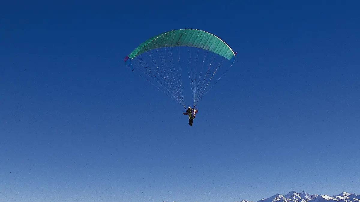 ein paraglider über einer Berglandschaft.