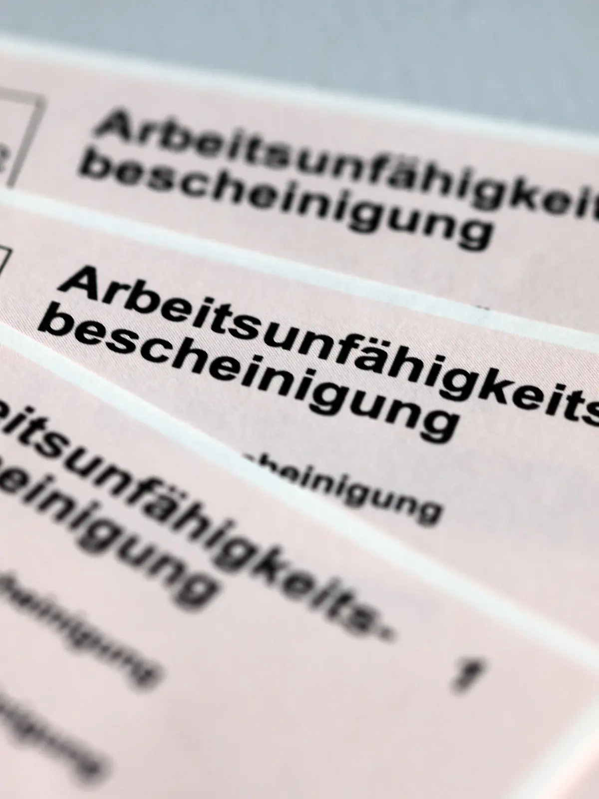 ARCHIV - 14.01.2022, Mecklenburg-Vorpommern, Schwerin: Arbeitsunfähigkeitsbescheinigungen für Arbeitnehmer im Falle einer Krankschreibung durch den Arzt. (zu dpa "Im Sommer bei DAK fast so hoher Krankenstand wie im Winter") Foto: Jens Büttner/dpa-Zentralbild/dpa +++ dpa-Bildfunk +++