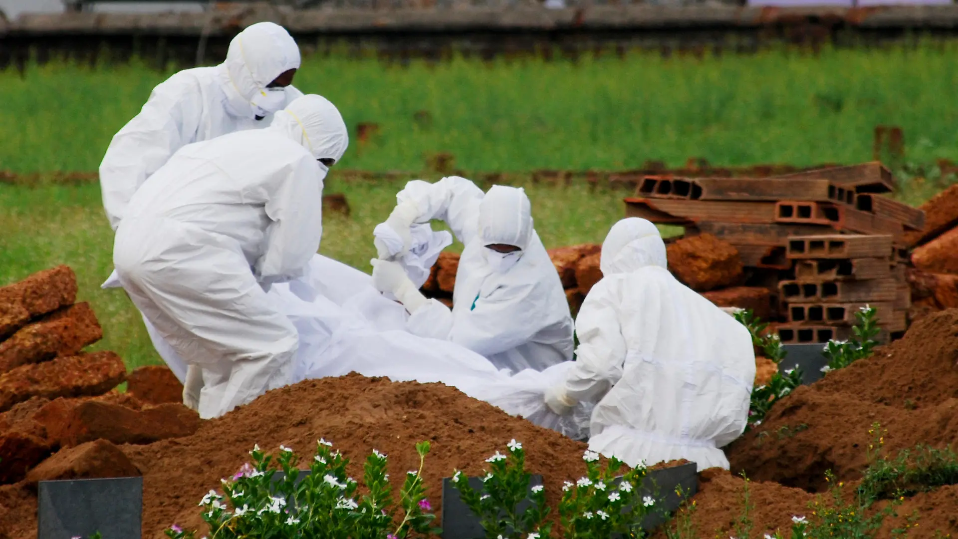 ARCHIV - 24.05.2018, Indien, Kozhikode: Rettungssanitäter in Schutzanzügen begraben ein Opfer, das aufgrund des Nipah-Virus verstarb. (Zu dpa "Nipah-Virus-Ausbruch: Schulen und Büros in Südindien geschlossen") Foto: K.Shijith/AP/dpa +++ dpa-Bildfunk +++