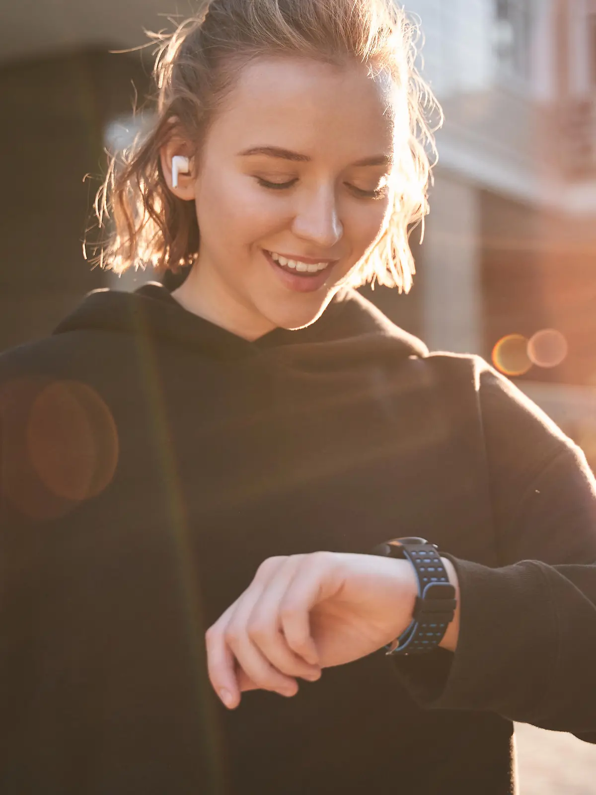 Fitness woman checking results on smartwatch in fitness app after workout session. Female athlete wearing sport tracker wristband arm. Healthy lifestyle concept