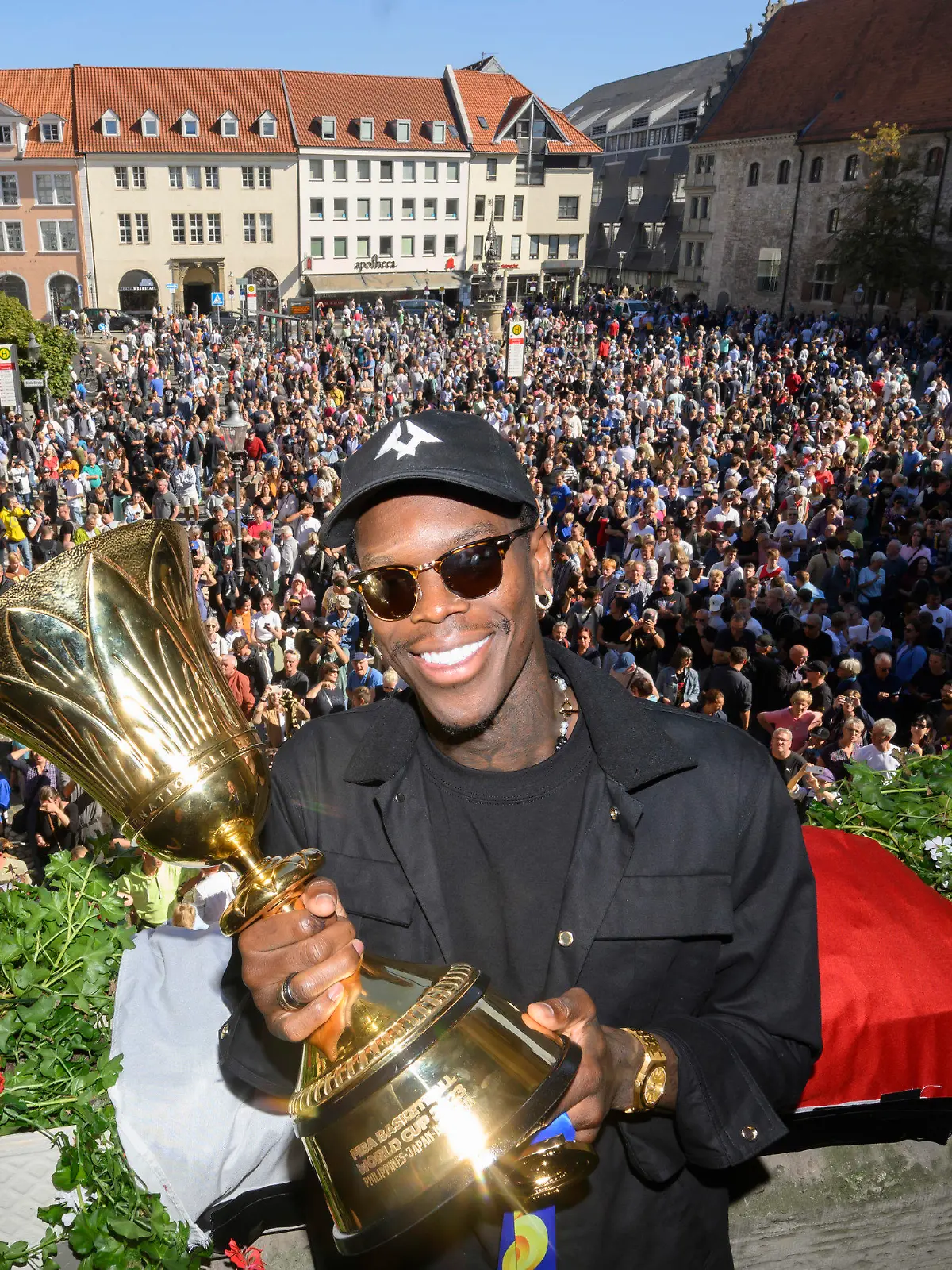 15.09.2023, Niedersachsen, Braunschweig: Dennis Schröder, Basketball-Weltmeister, steht bei einem Empfang auf dem Balkon vom Braunschweiger Rathaus. NBA-Basketballspieler Dennis Schröder hat sich ins Goldene Buch der Stadt Braunschweig eingetragen und von tausenden Fans in seiner Heimatstadt feiern lassen. Foto: Julian Stratenschulte/dpa +++ dpa-Bildfunk +++