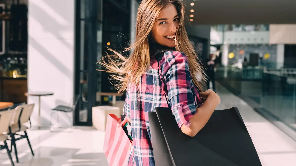 Happy girl with shopping bags looking over shoulder