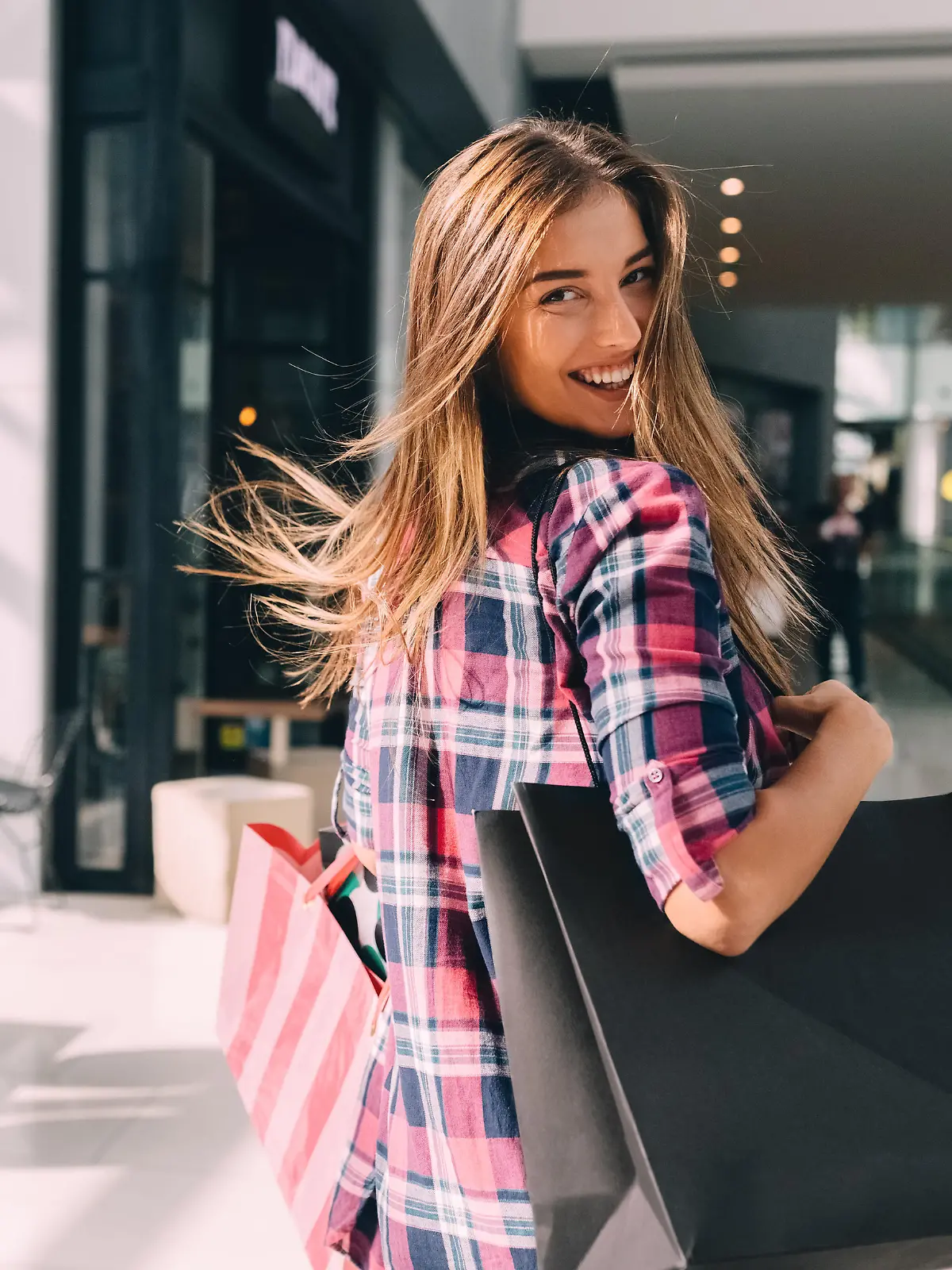 Happy girl with shopping bags looking over shoulder