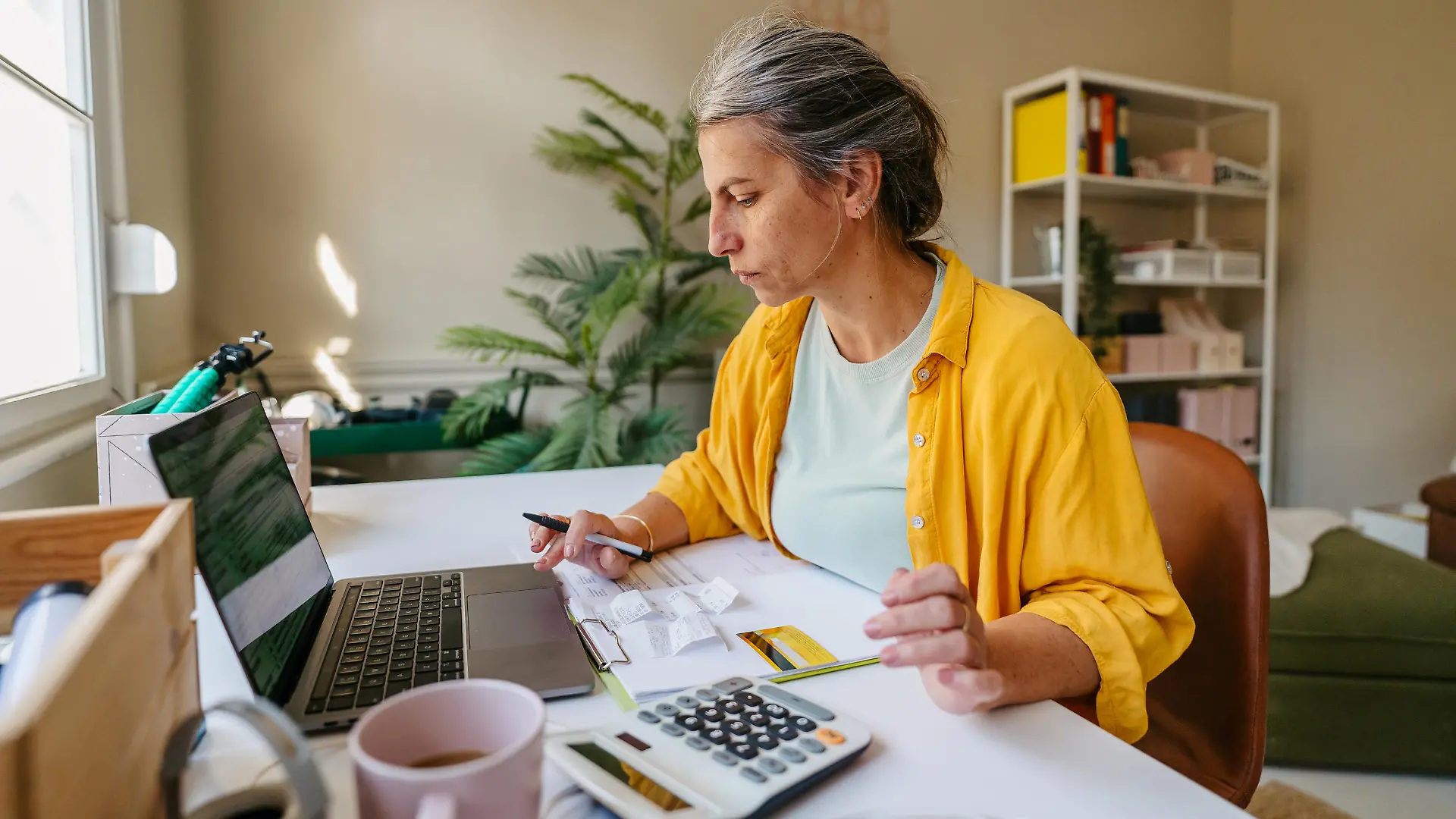 Photo of a woman calculating and paying online her income tax