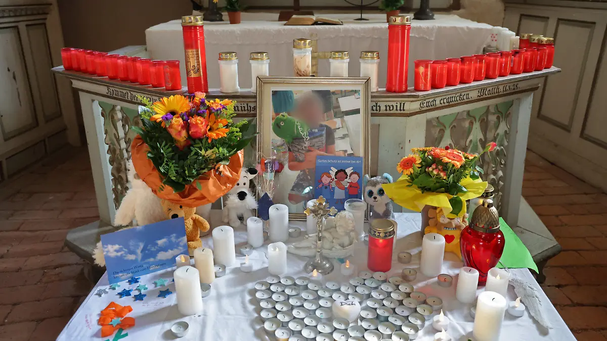 18.09.2023, Mecklenburg-Vorpommern, Pragsdorf: Auf dem Altar in der Kirche stehen Kerzen, Blumen und Fotos zum Gedenken an den Sechsjährigen. Die Ermittlungen nach der Tötung eines Sechsjährigen am See laufen nach wie vor auf Hochtouren. Foto: Bernd Wüstneck/dpa - ACHTUNG: Person(en) wurde(n) aus rechtlichen Gründen gepixelt +++ dpa-Bildfunk +++