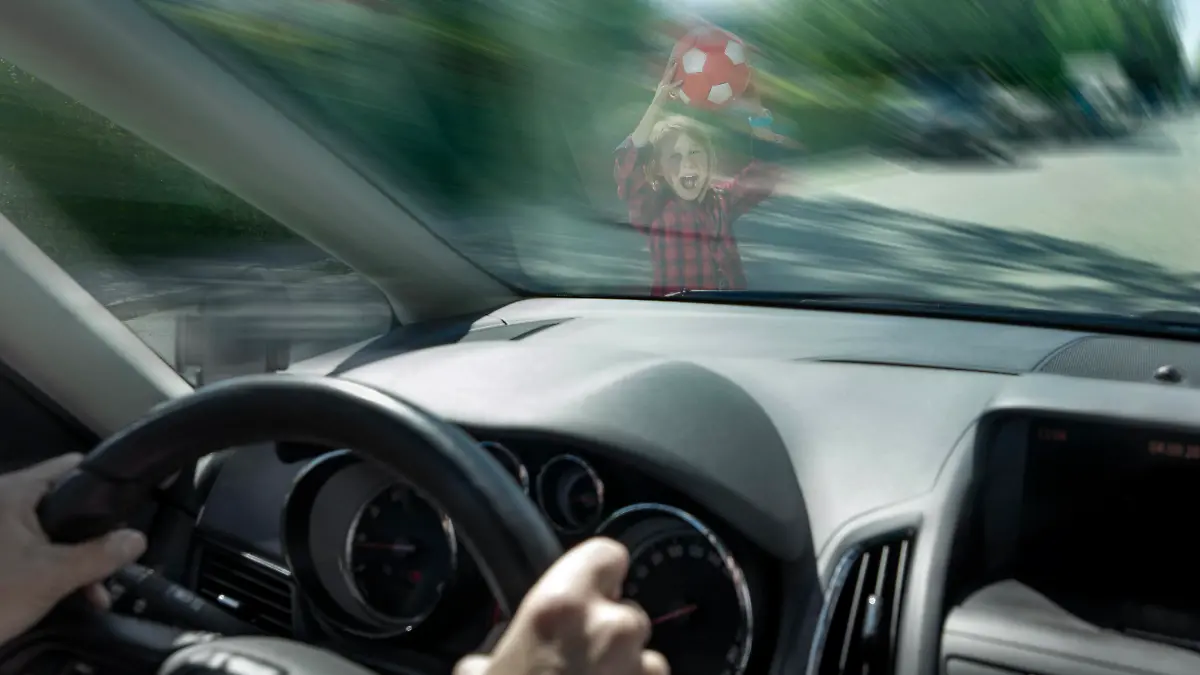 Scared boy with ball seen through windshield of car trying to prevent accident model released, Symbolfoto, RNF01388