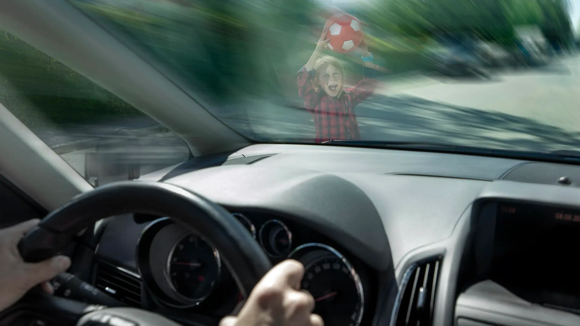 Scared boy with ball seen through windshield of car trying to prevent accident model released, Symbolfoto, RNF01388
