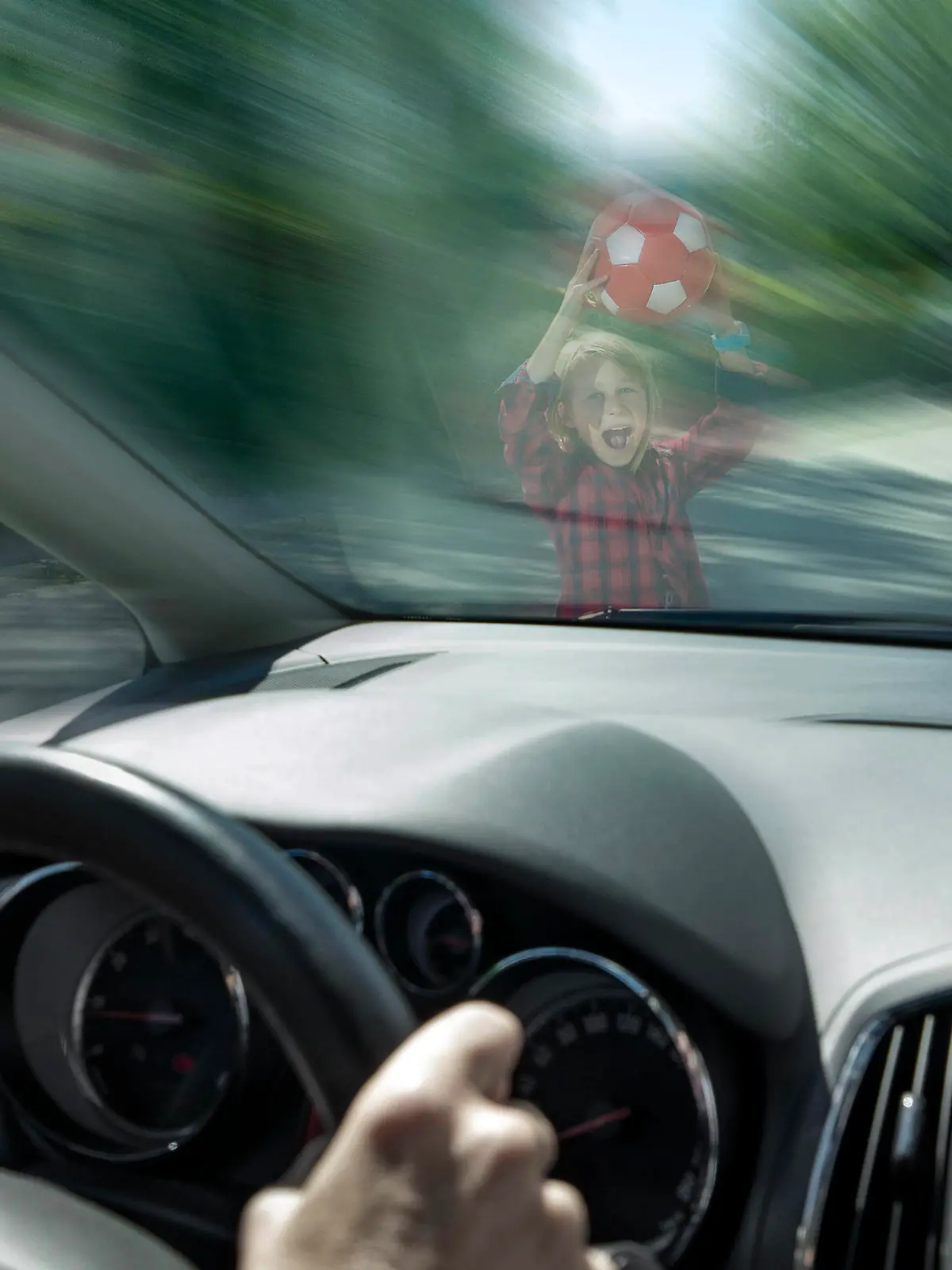 Scared boy with ball seen through windshield of car trying to prevent accident model released, Symbolfoto, RNF01388