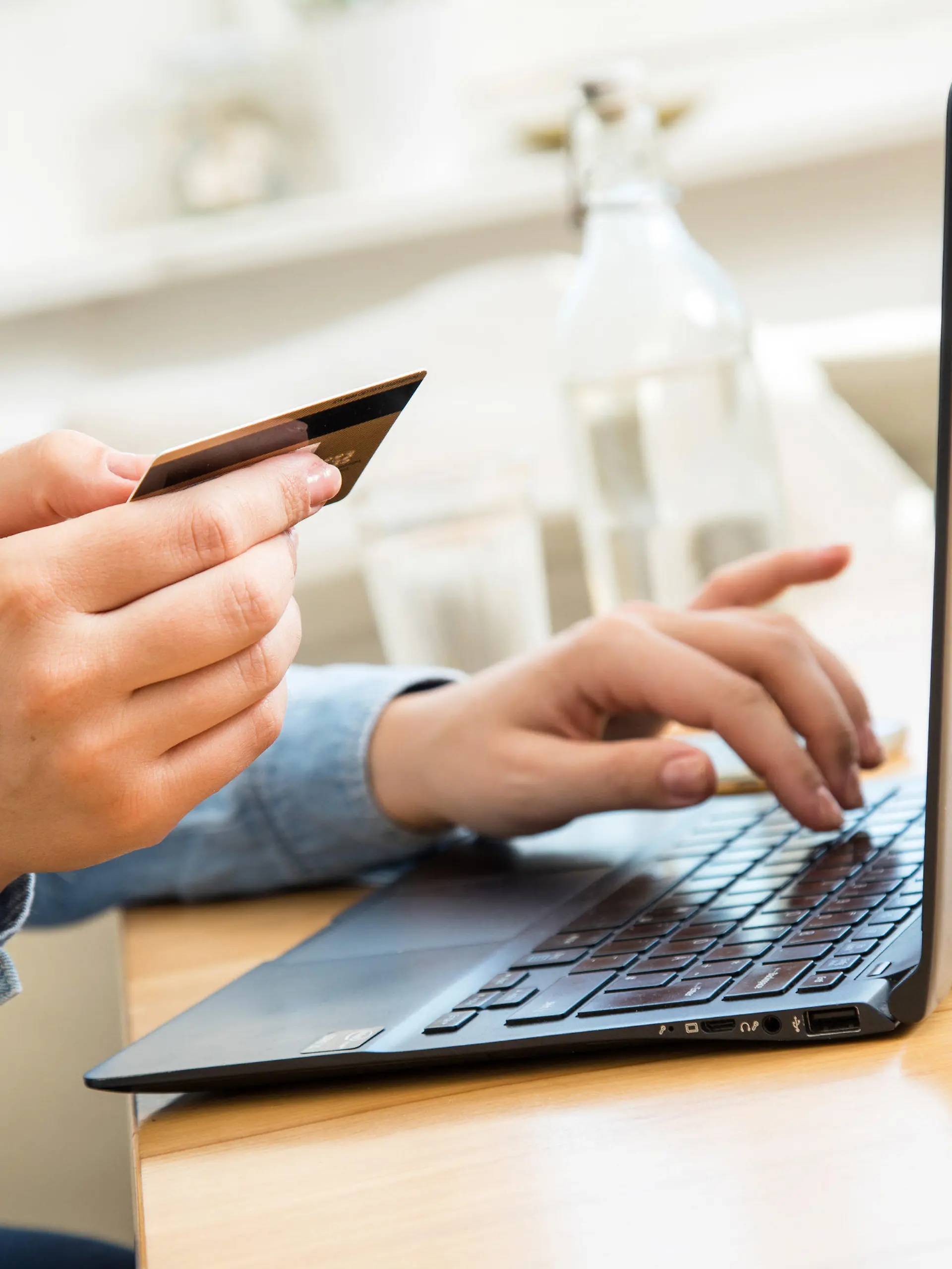 ARCHIV - 01.10.2020, Brandenburg, Wittenberge: ILLUSTRATION - Eine Frau sitzt mit einer Kreditkarte am Laptop. Der drastische Anstieg der Lebenshaltungskosten in Deutschland hat auch das Einkaufsverhalten der Online-Shopper verändert. Die Menschen überlegen sorgfältiger, was sie wirklich brauchen und achten vermehrt auf Sonderangebote.      (zu dpa "Umfrage: Auch beim Online-Shoppen wird gespart") Foto: Christin Klose/dpa +++ dpa-Bildfunk +++
