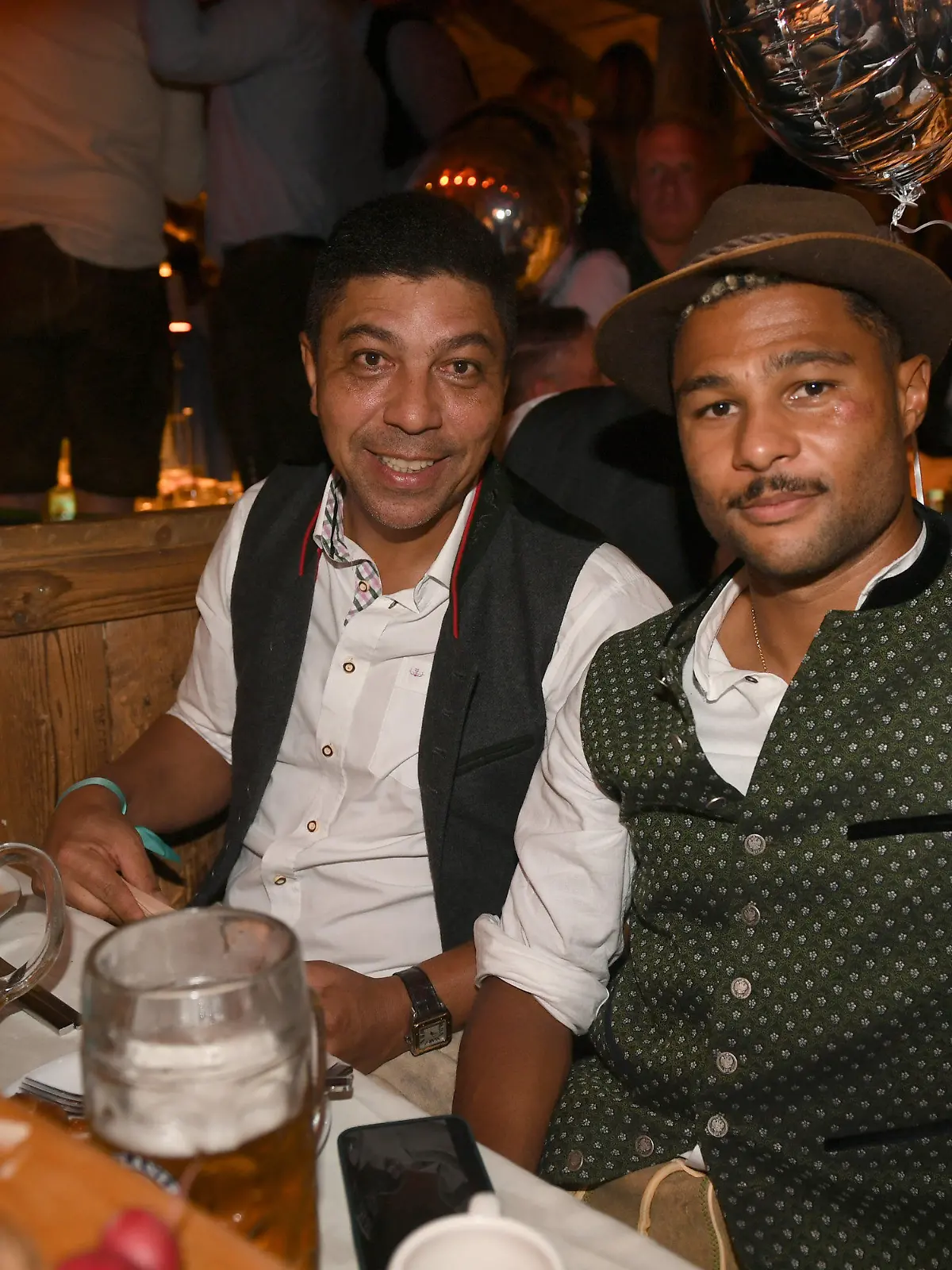 17.09.2023, Bayern, München: Die Fußballer Giovane Elber (l) und Serge Gnabry feiern beim 25 jährigen Jubiläum des "Almauftrieb" im Käfer-Zelt. Die 188. Wiesn findet dieses Jahr vom 16.09.- 03.10.2023 statt. Foto: Felix Hörhager/dpa +++ dpa-Bildfunk +++