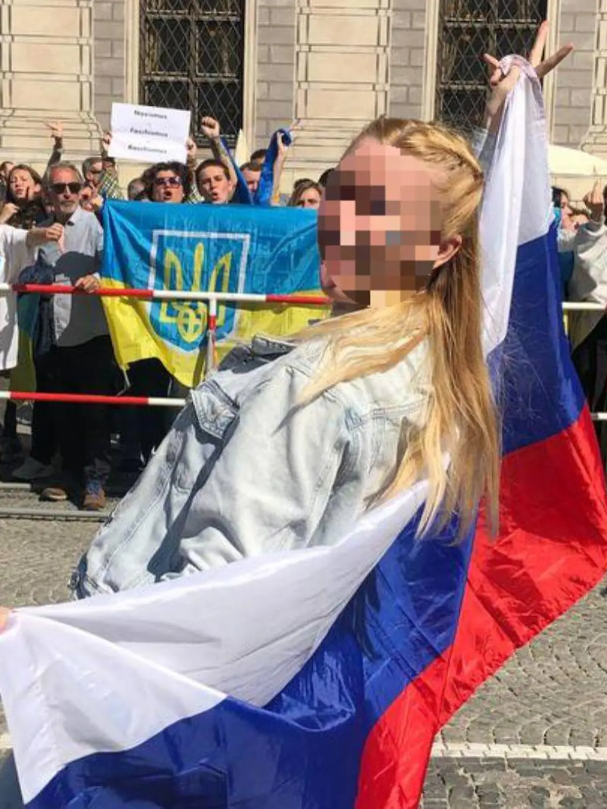 Julia P. posiert mit russischer Flagge in München vor Teilnehmern einer Pro-Ukraine-Demo. Nach ihrem Auftritt gingen mehrere Strafanzeigen bei diversen Polizeibehörden ein.
