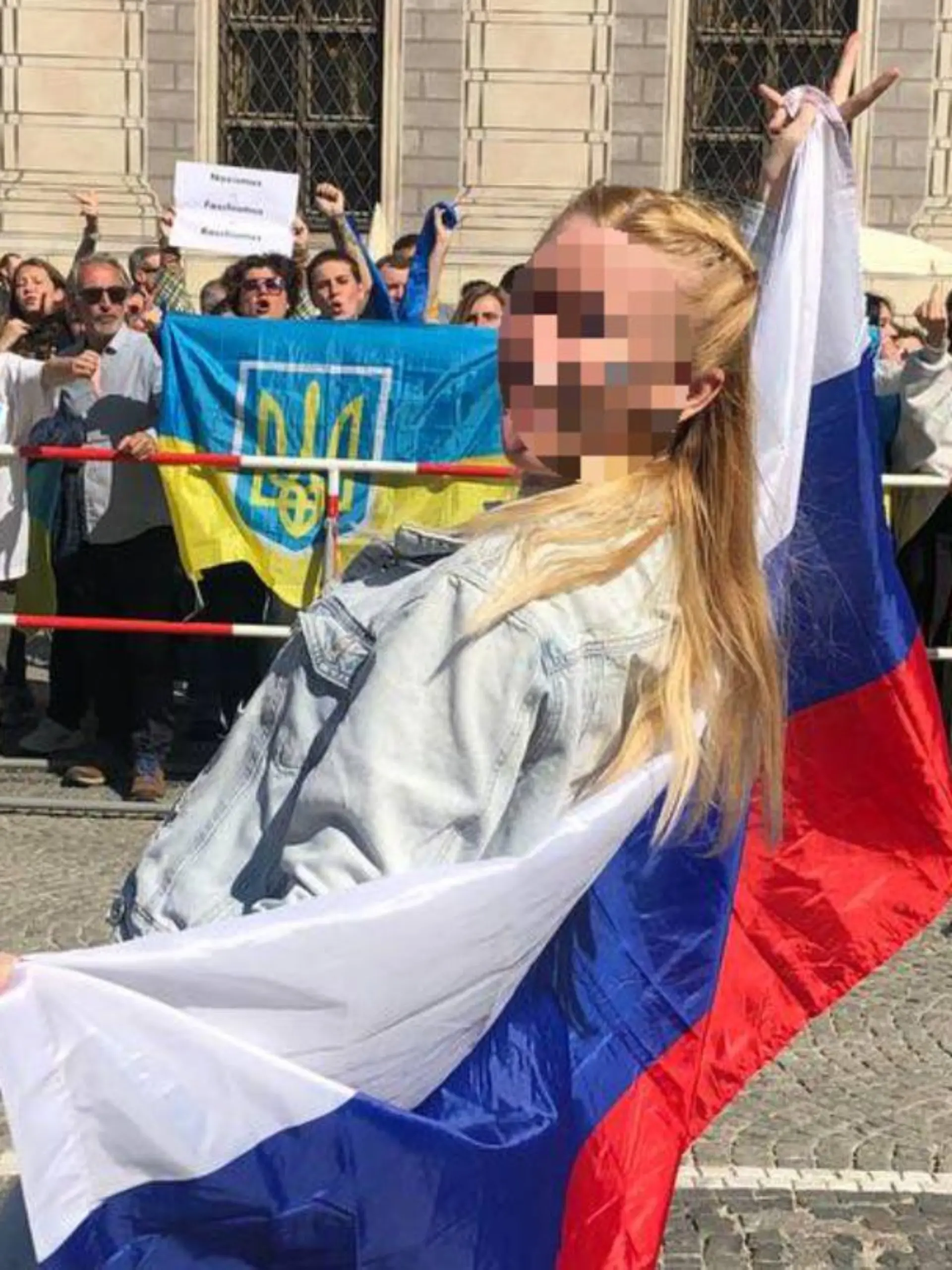 Julia P. posiert mit russischer Flagge in München vor Teilnehmern einer Pro-Ukraine-Demo. Nach ihrem Auftritt gingen mehrere Strafanzeigen bei diversen Polizeibehörden ein.