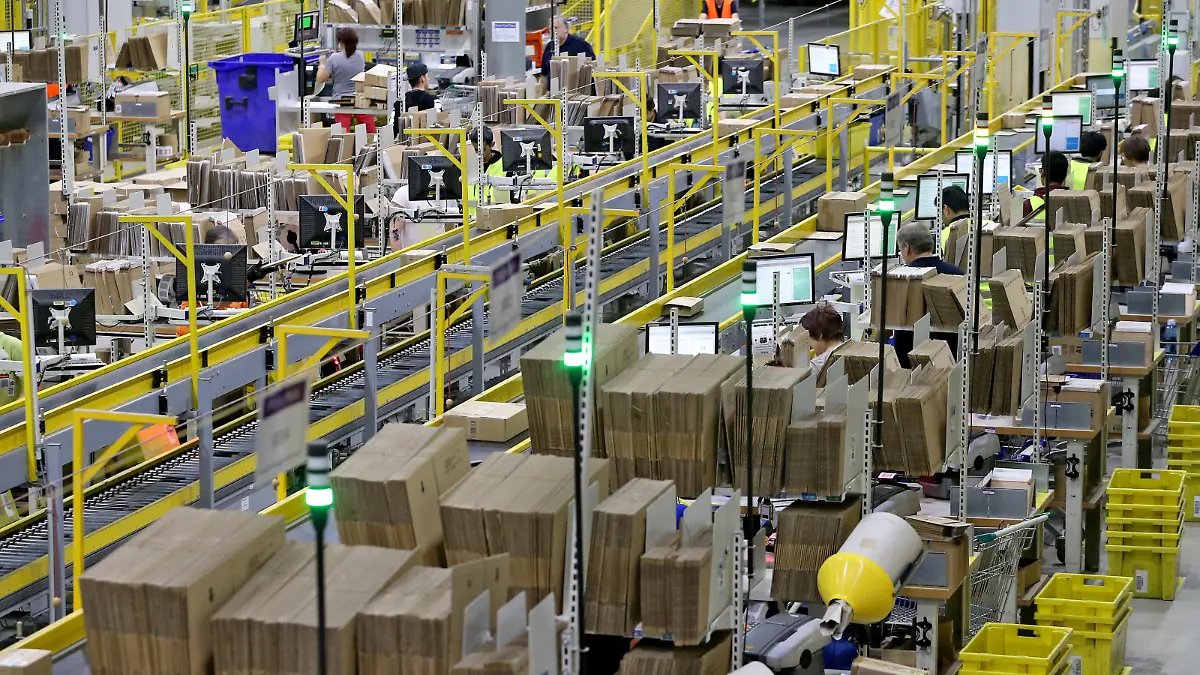 Mitarbeiter des Amazon-Logistikzentrums in Leipzig (Sachsen) verpacken am 19.11.2015 Waren für den Paketversand. Für den Online-Versandhändler mit seinen über zwei Millionen Kunden weltweit beginnt jetzt das Weihnachtsgeschäft. Im Versandzentrum Leipzig beschäftigt Amazon derzeit rund 2700 Mitarbeiter. Foto: Jan Woitas/dpa