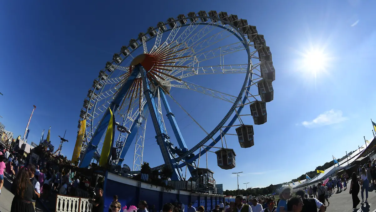 16.09.2023, Bayern, München: Die Sonne scheint hinter dem Riesenrad am blauen Himmel. Die 188. Wiesn findet dieses Jahr vom 16.09.- 03.10.2023 statt. Foto: Felix Hörhager/dpa +++ dpa-Bildfunk +++