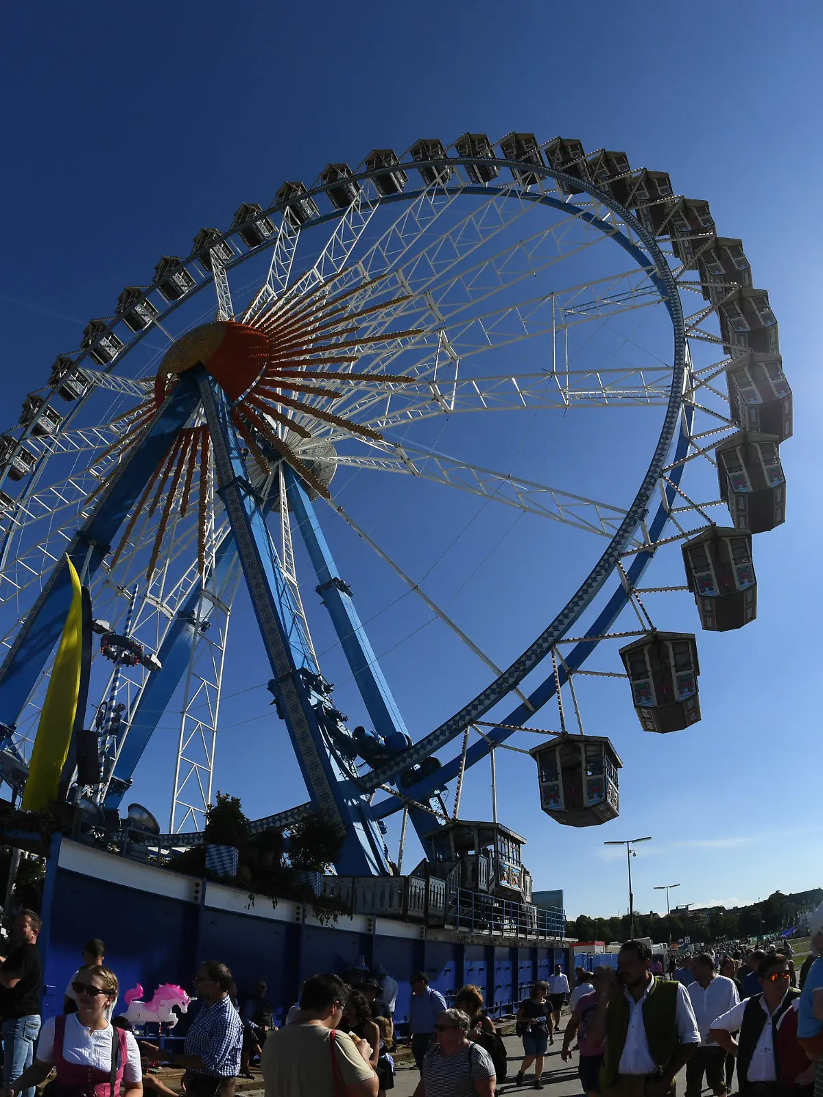 16.09.2023, Bayern, München: Die Sonne scheint hinter dem Riesenrad am blauen Himmel. Die 188. Wiesn findet dieses Jahr vom 16.09.- 03.10.2023 statt. Foto: Felix Hörhager/dpa +++ dpa-Bildfunk +++