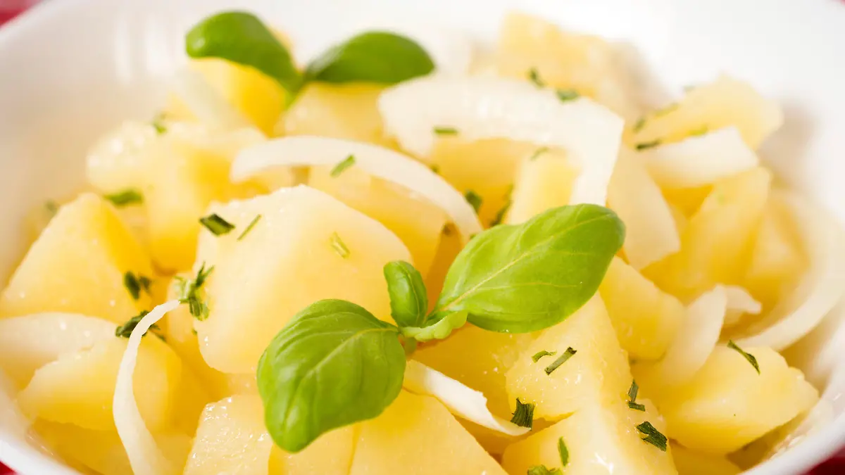 Selective focus in the middle of traditional German potato salad with onion