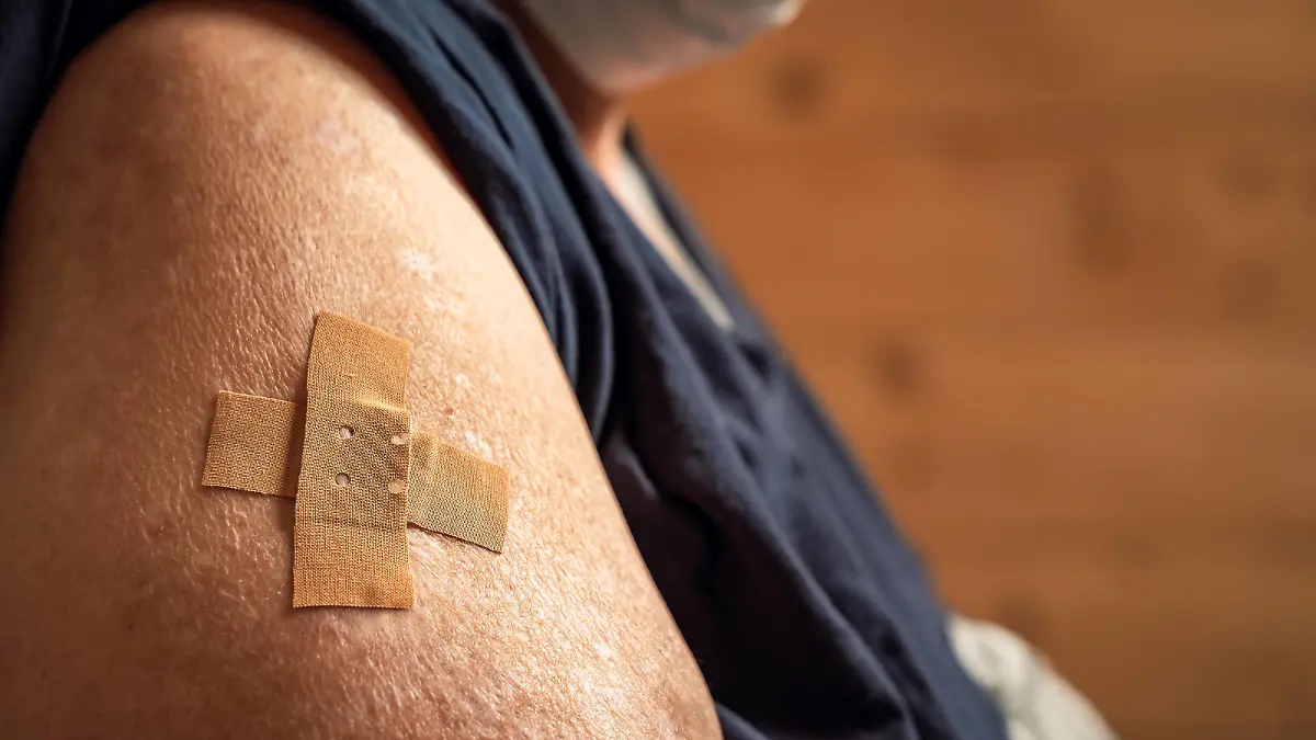  Mindelheim, Bavaria, germany - 01 may 2021: overweight woman shows her arm after being vaccinated. arm with adhesive bandage after injection. Health concept