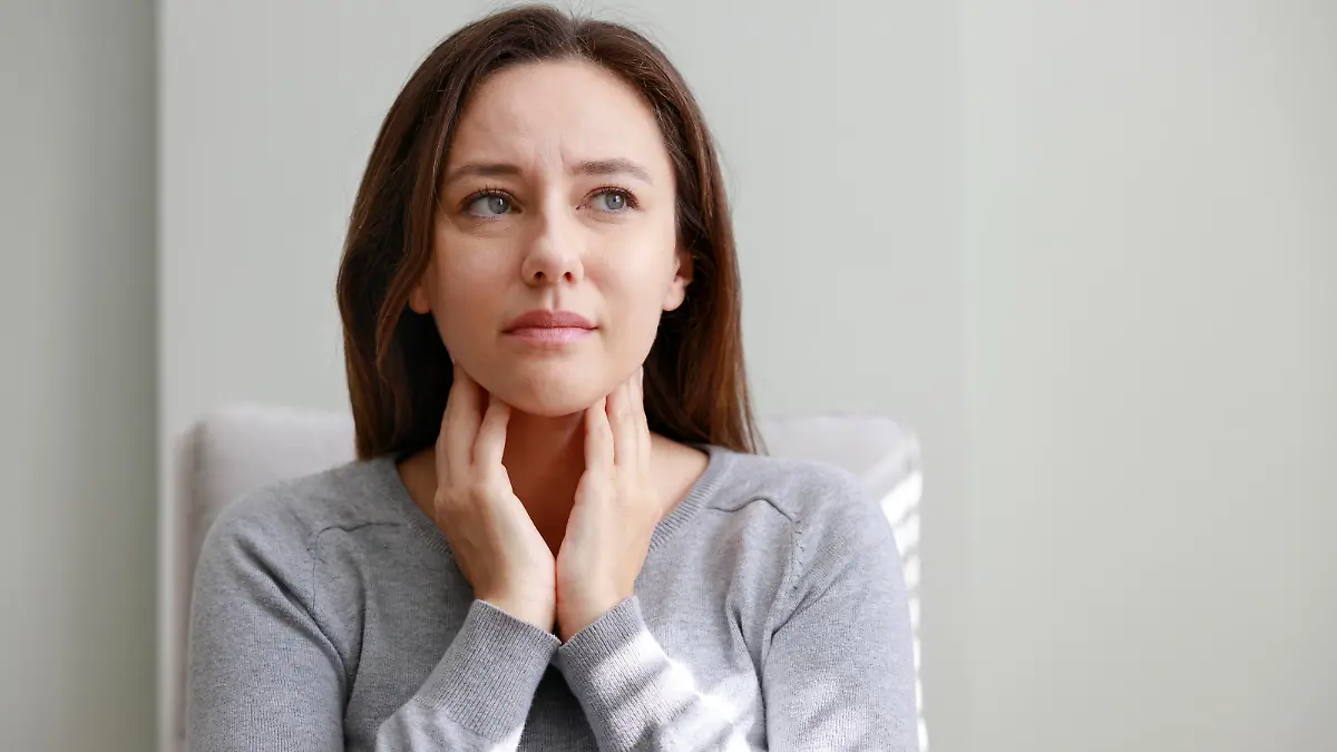Young woman touching painful neck, sore throat for flu, cold and infection