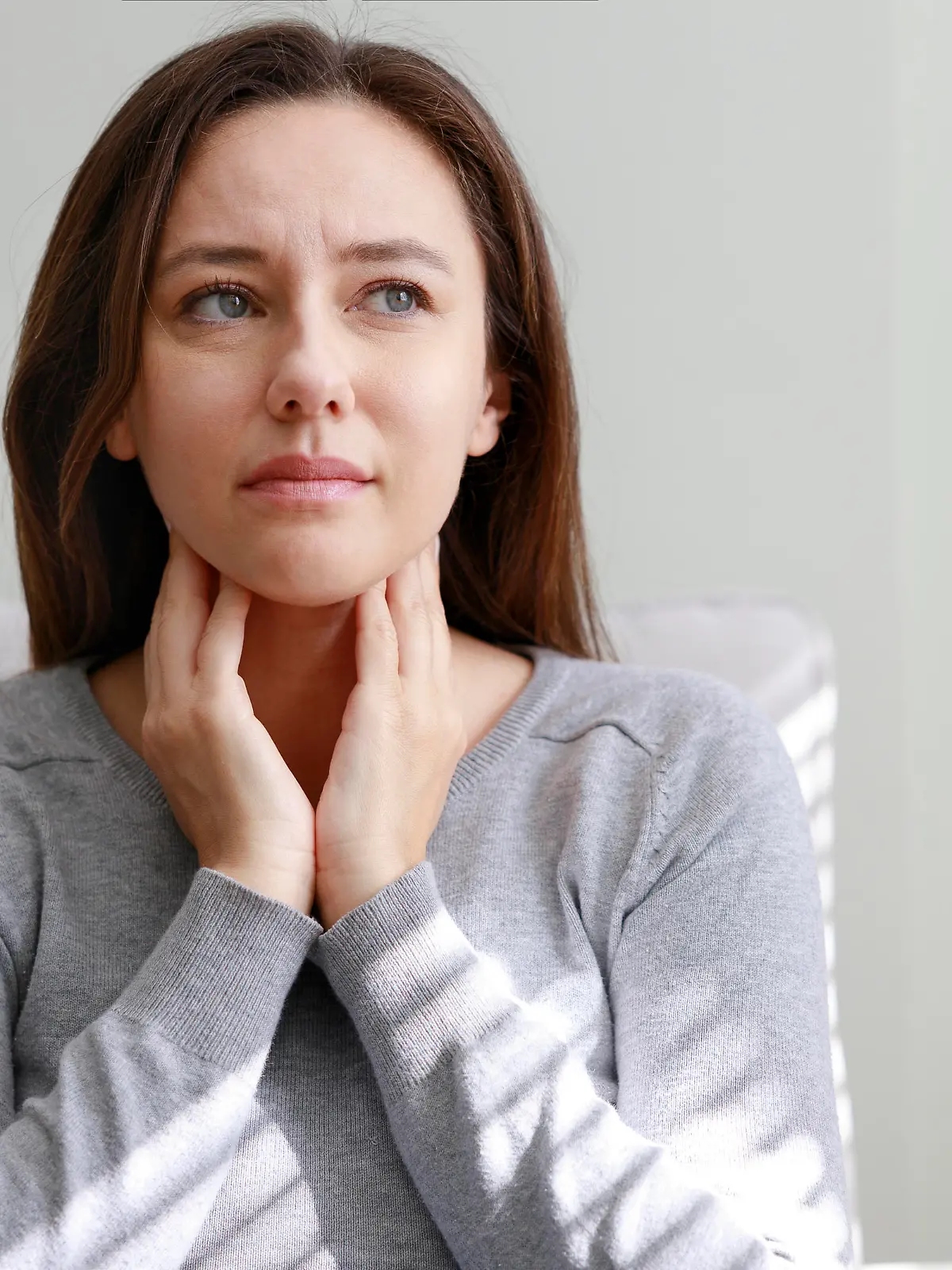 Young woman touching painful neck, sore throat for flu, cold and infection