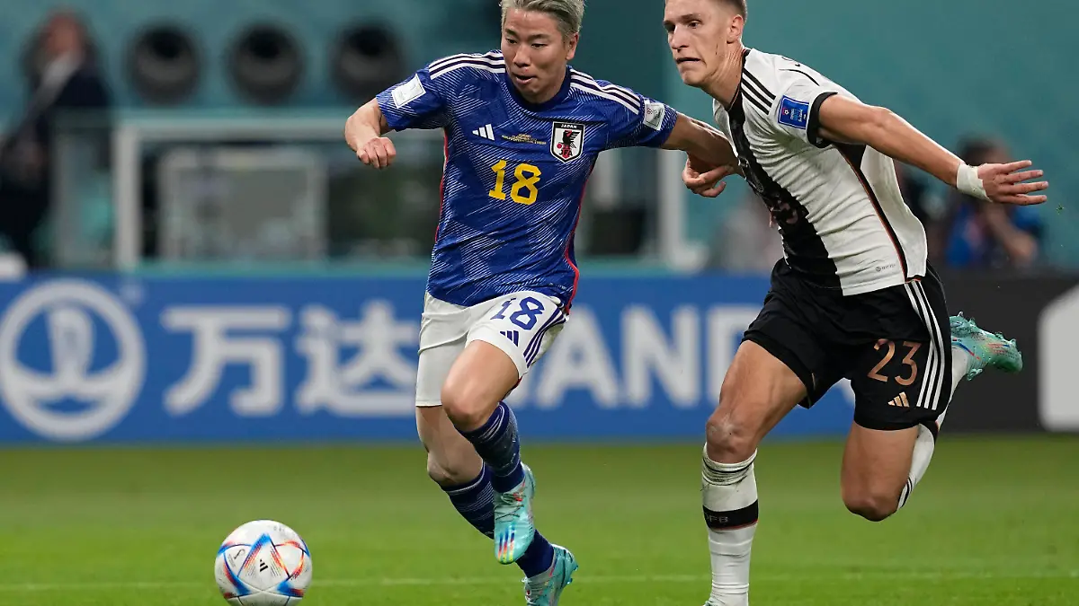Japan's Takuma Asano, left, fight for the ball with Germany's Nico Schlotterbeck, on his way to score his side's second goal during the World Cup group E soccer match between Germany and Japan, at the Khalifa International Stadium in Doha, Qatar, Wednesday, Nov. 23, 2022. (AP Photo/Ebrahim Noroozi)