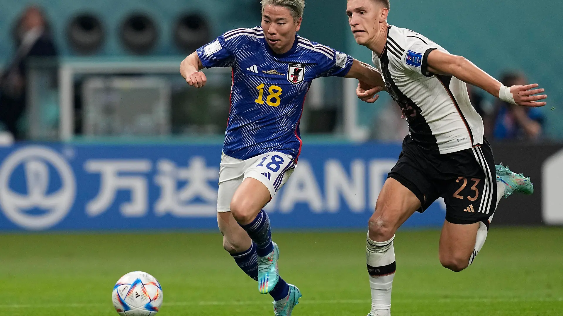 Japan's Takuma Asano, left, fight for the ball with Germany's Nico Schlotterbeck, on his way to score his side's second goal during the World Cup group E soccer match between Germany and Japan, at the Khalifa International Stadium in Doha, Qatar, Wednesday, Nov. 23, 2022. (AP Photo/Ebrahim Noroozi)