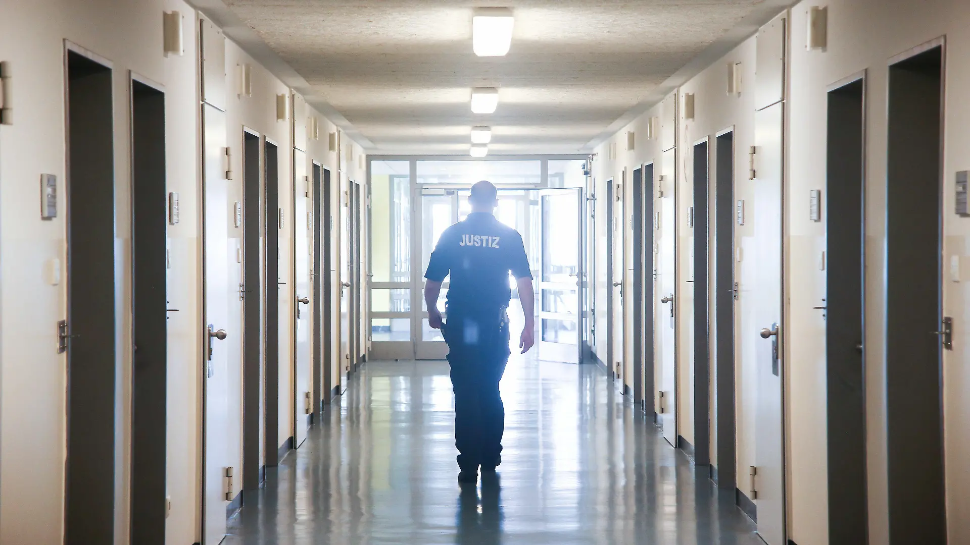 ARCHIV - 19.06.2017, Hamburg: Ein Vollzugsbeamter geht in der JVA Billwerder in Hamburg einen Gang entlang. Bei Kontrollen in den sechs Gefängnissen der Hansestadt sind auch 2019 und in den ersten neun Monaten 2020 zahlreiche Messer, Drogen und Handys gefunden worden. (zu dpa «Zahlreiche Messer, Handys und Drogen in Hamburger Gefängnissen») Foto: picture alliance / Ulrich Perrey/dpa +++ dpa-Bildfunk +++
