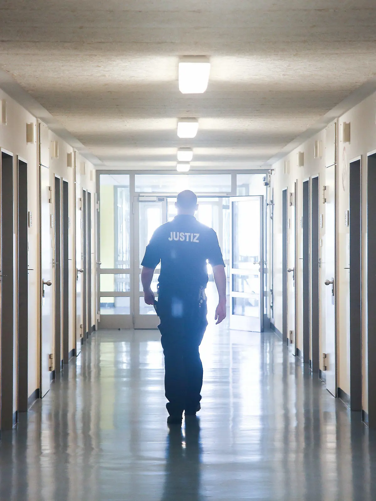 ARCHIV - 19.06.2017, Hamburg: Ein Vollzugsbeamter geht in der JVA Billwerder in Hamburg einen Gang entlang. Bei Kontrollen in den sechs Gefängnissen der Hansestadt sind auch 2019 und in den ersten neun Monaten 2020 zahlreiche Messer, Drogen und Handys gefunden worden. (zu dpa «Zahlreiche Messer, Handys und Drogen in Hamburger Gefängnissen») Foto: picture alliance / Ulrich Perrey/dpa +++ dpa-Bildfunk +++