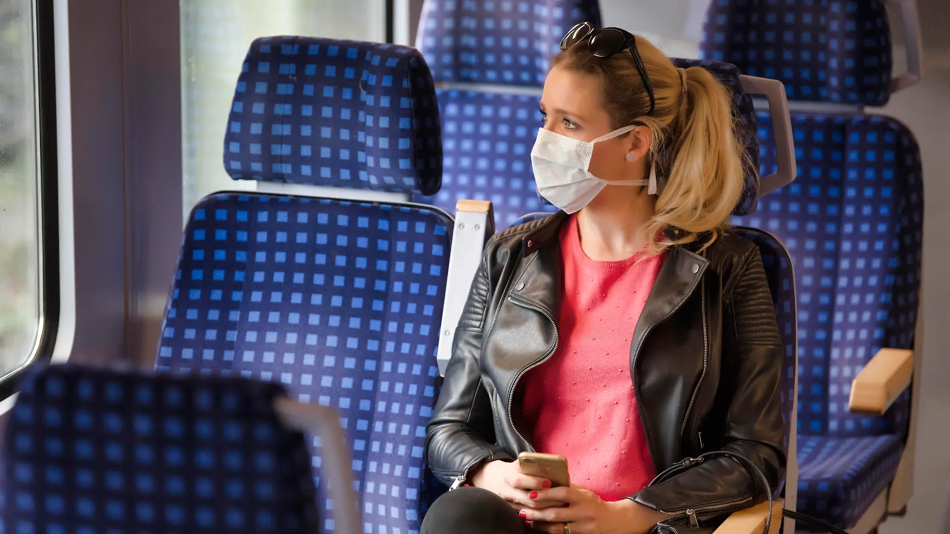 Frau mit Mundschutzmaske, sitzt in Zug, am Handy, Corona-Krise, Stuttgart, Baden-Württemberg, Deutschland Coronavirus *** Woman with a face mask, sitting in Zug, on a mobile phone, corona crisis, Stuttgart, Baden Württemberg, Germany Coronavirus