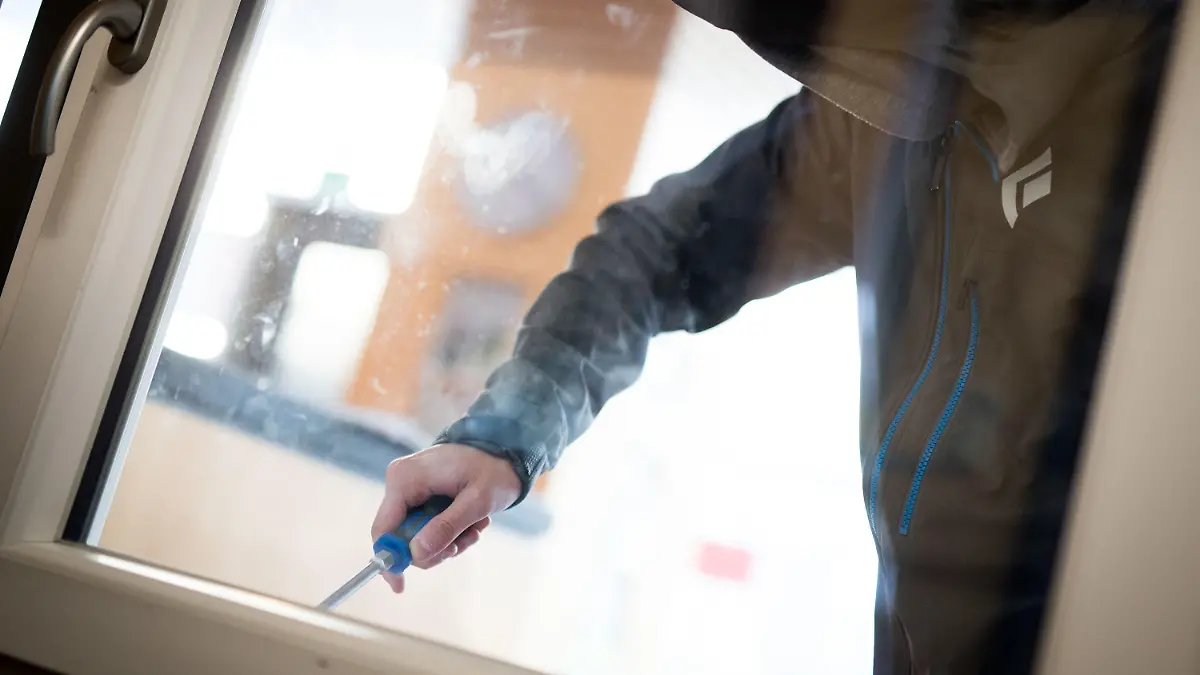 ARCHIV - 10.04.2015, Hessen, Frankfurt/Main: ILLUSTRATION - Ein Mann demonstriert in der polizeilichen Beratungsstelle, wie einfach es für einen Einbrecher wäre, mit Hilfe eines stabilen Schraubenziehers ein geschlossenes Fenster von außen zu öffnen. (zu dpa: "Hunderte Einbrüche in Berliner Schulen pro Jahr") Foto: Frank Rumpenhorst/dpa +++ dpa-Bildfunk +++