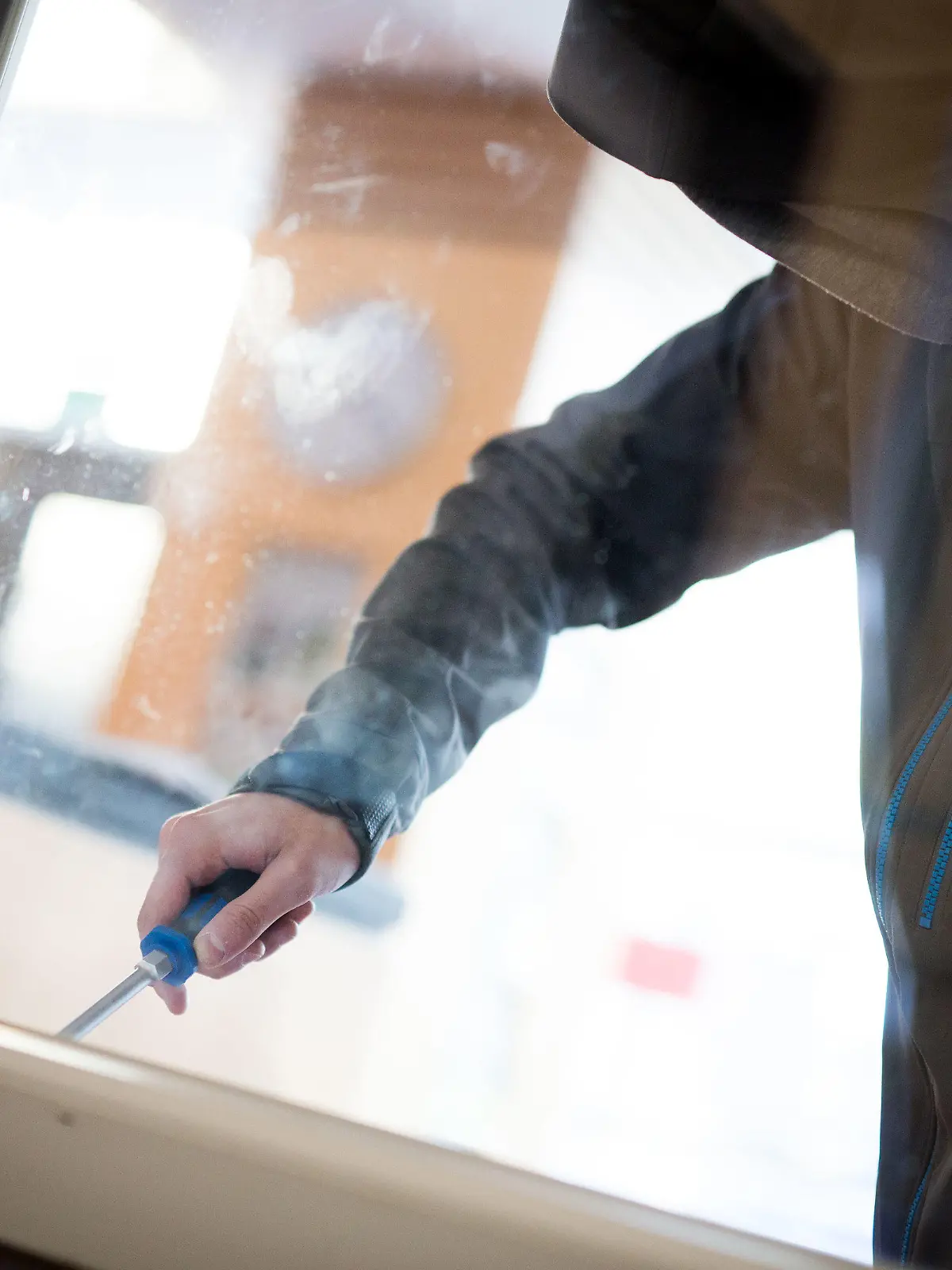 ARCHIV - 10.04.2015, Hessen, Frankfurt/Main: ILLUSTRATION - Ein Mann demonstriert in der polizeilichen Beratungsstelle, wie einfach es für einen Einbrecher wäre, mit Hilfe eines stabilen Schraubenziehers ein geschlossenes Fenster von außen zu öffnen. (zu dpa: "Hunderte Einbrüche in Berliner Schulen pro Jahr") Foto: Frank Rumpenhorst/dpa +++ dpa-Bildfunk +++