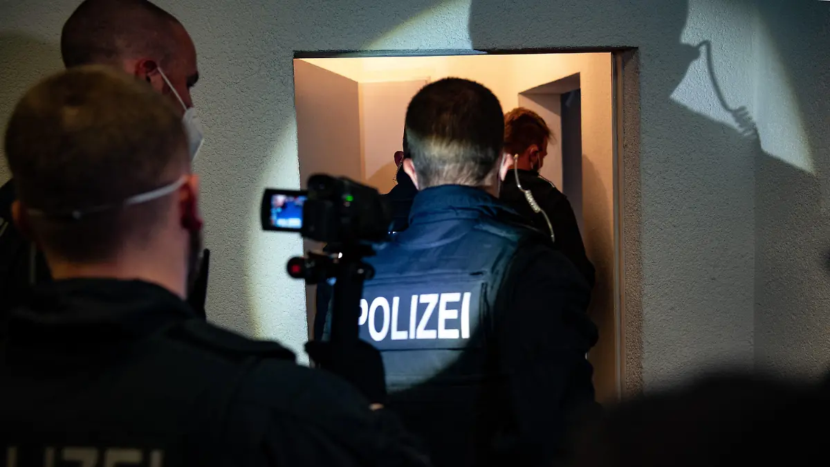 31.05.2021, Berlin: Bundespolizisten gehen bei einer Razzia gegen Schleuser in eine Wohnung. Bei einer großangelegten Razzia gingen Bundespolizisten in mehreren Bundesländern gegen Schleuserkriminalität vor. (Zu dpa «Bundesweite Razzien gegen organisierte Schleuserkriminalität») Foto: Paul Zinken/dpa-Zentralbild/dpa +++ dpa-Bildfunk +++